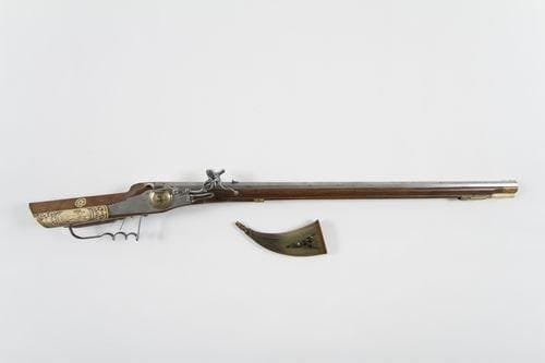 Poire à poudre-clef à rouet en corne claire.   Fond en bois. Présentant sur une face trois carrés faisant clef à rouet en fer forgé renforcé d?une plaque de laiton découpée gravée de l?autre côté.  B.E. XVIIe siècle.