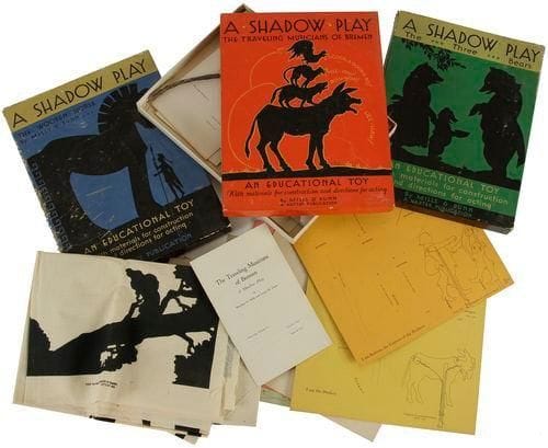 The Siege of Troy or the Wooden Horse, Shadow play for young people by Winifreed H. Mille and Louise M. Dunn, (1 prologue, 3 actes et 1 épilogue). The Harter publishing company. Cleveland, Ohio. Copyright 1931. Boîte contenant tous les décors imprimés en noir sur toile, tous les personnages sur carte perforée, les baguettes de bois pour le montage des silhouettes, les tiges de commande et attaches pour les pièces mobiles, les shémas de montage, le texte à jouer. 60 x 80 cm environ Série de trois pièces de cette publication enfantine. Défauts à la boîte