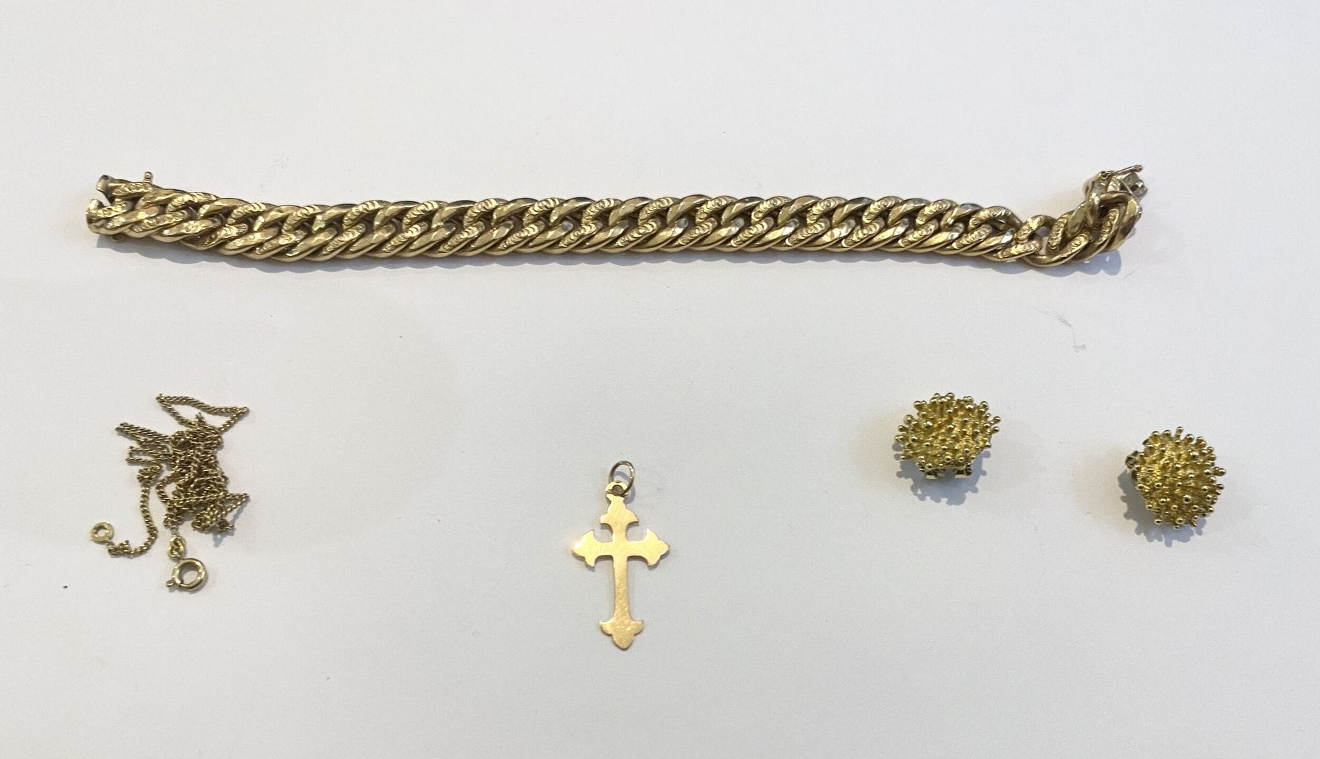 Lot d'or jaune 750/°°° comprenant : 
Un bracelet mailles américaines, une paire de clips d'oreilles, et un pendentif formant une croix.
Poids. : 28,17 g 
On joint une chaine en métal doré.