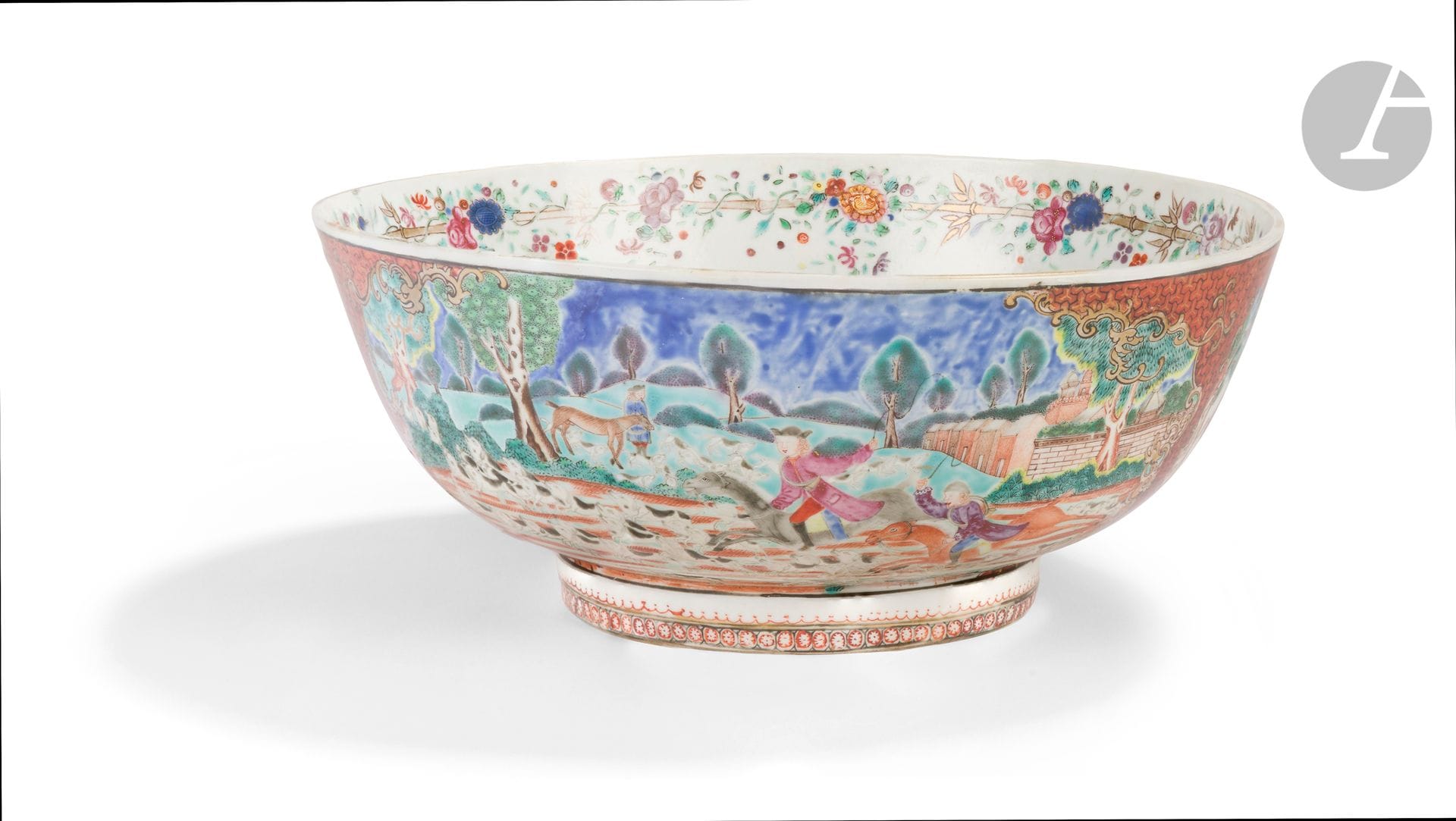 Famille rose porcelain punch bowl decorated with hunting scenes, China, Compagnie des Indes, 18th century
On an iron-red and gold ground with geometric motifs, the outside of the bowl is decorated with two large cartouches depicting a fox hunt with horsemen and hunting dogs in a landscape with Western architecture in the distance, and two smaller cartouches depicting Chinese scenes with figures and children in gardens near traditional dwellings. The interior of the bowl is decorated around the rim with a frieze of flowers wrapped around a bamboo stem. In the background, a medallion depicts a Chinese horseman escorted by two men on foot, one shooting a fox with a rifle, the other carrying a stick on his shoulder from which birds hang. Two dogs accompany them.
Diameter: 28.5 cm
Significant restoration.
