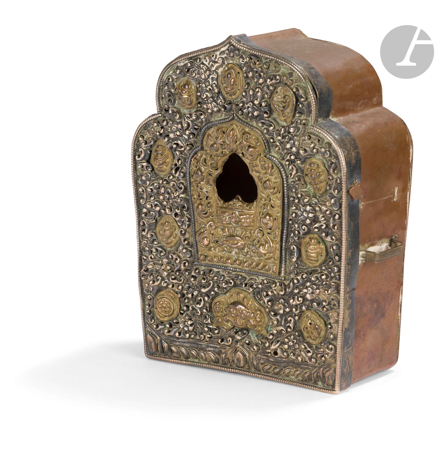 G'au in copper alloy and silver plated metal, Tibet, 20th century
Traveling reliquary in the form of a broken arch with a window opening. The silver cover is decorated on the front with repoussé scrolls and gilded medallions depicting auspicious symbols and a Makara head. The back is in copper alloy. Two strap fasteners on each side, one missing.
Height: 15.3 cm
