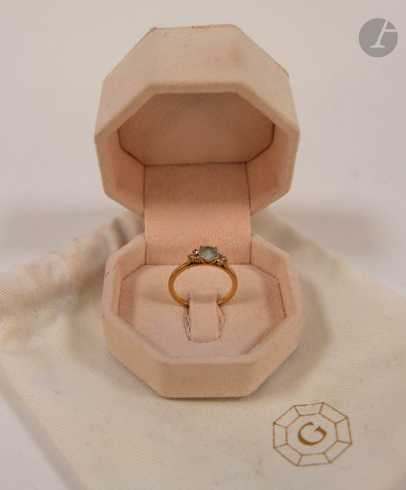 GEMMYO Ring in 18K (750) gold, featuring a round aquamarine set with 3 round brilliant-cut diamonds. Preserved in its case. Unsigned. Finger size: 49. Gross weight: 2.1 g (scratches, micro-shock).