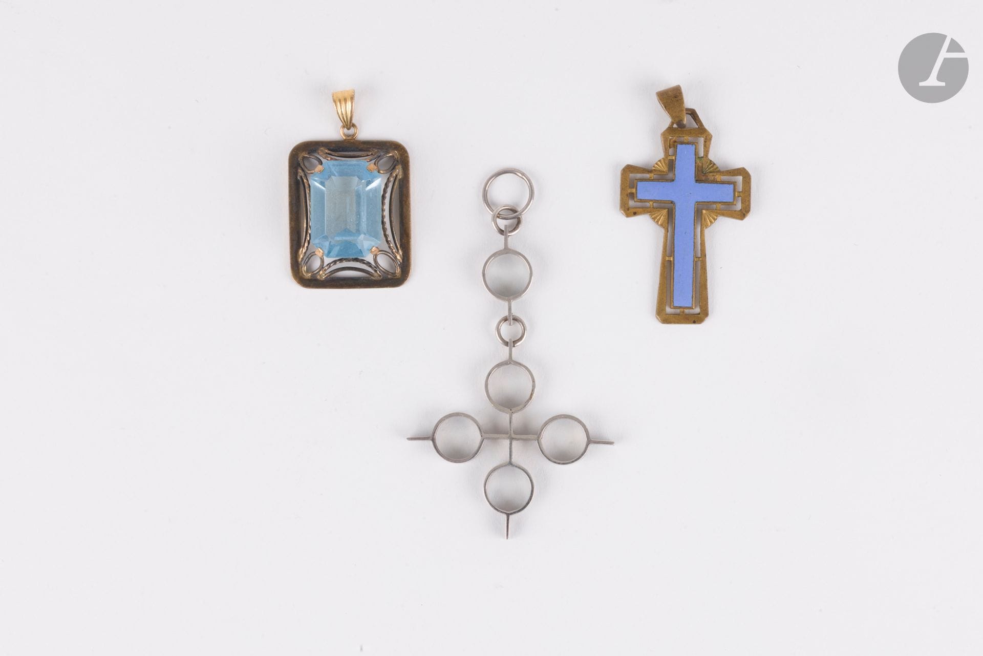 Suite de 3 pendentifs en métal dont l'un orné d'une pierre bleue synthétique, un autre formant une croix émaillée.