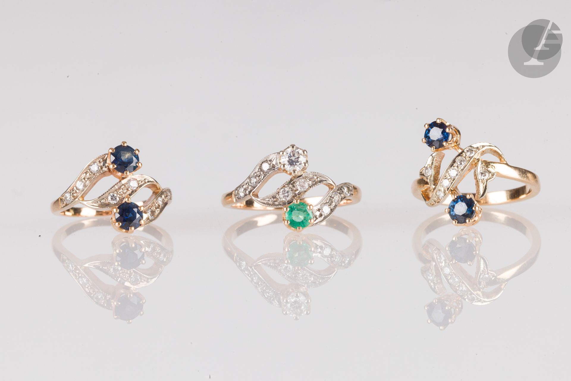 Lot de 3 bagues en or 18K (750), les deux premières croisées serties de saphirs et de diamants, la 3e agrémentée d'une émeraude et de diamants. Poids brut : 8,9 g