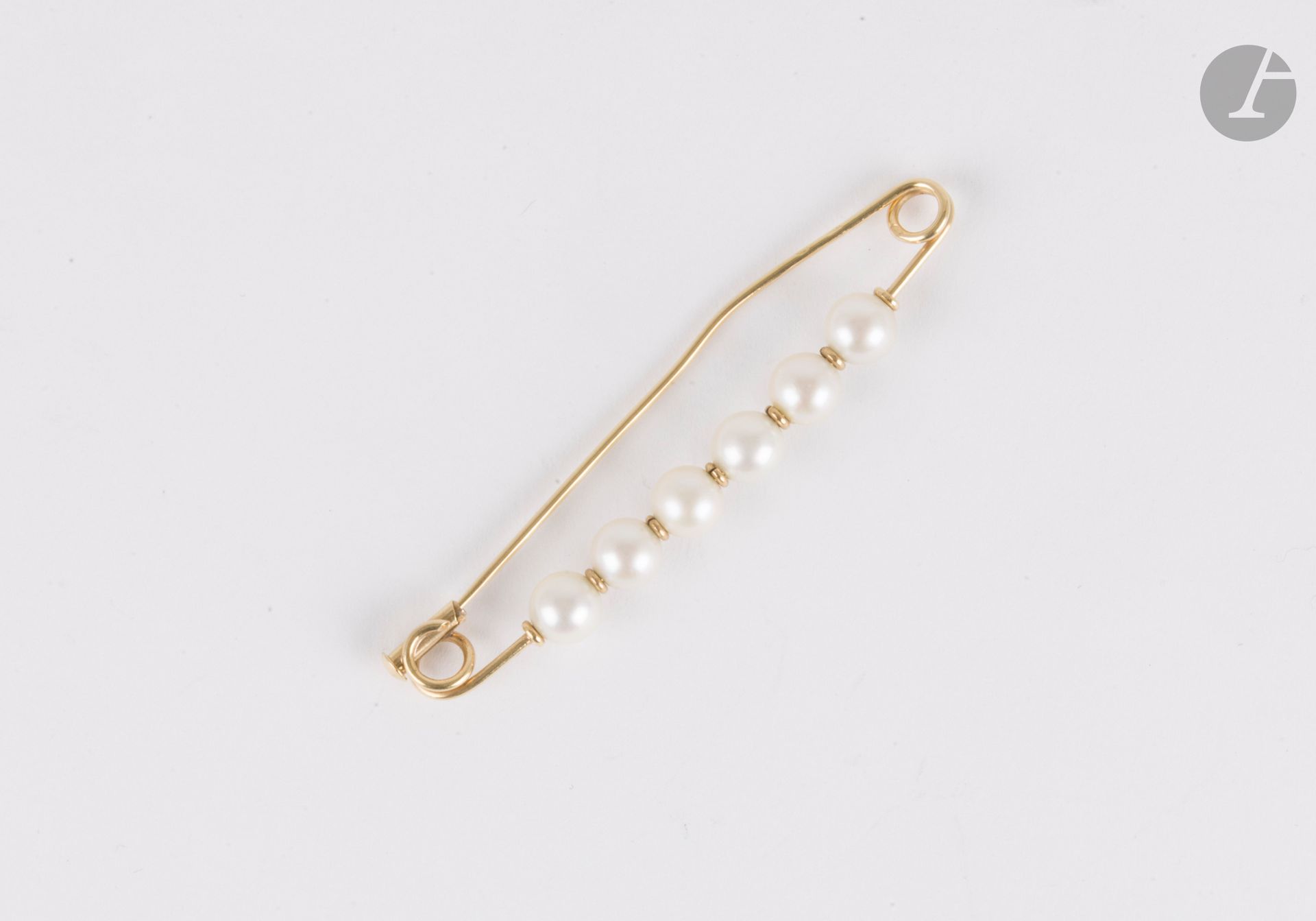 Broche en or 18K (750), ornée de 6 perles de culture. Longueur : 6 cm environ. Poids brut : 4,1 g (aiguille déformée)