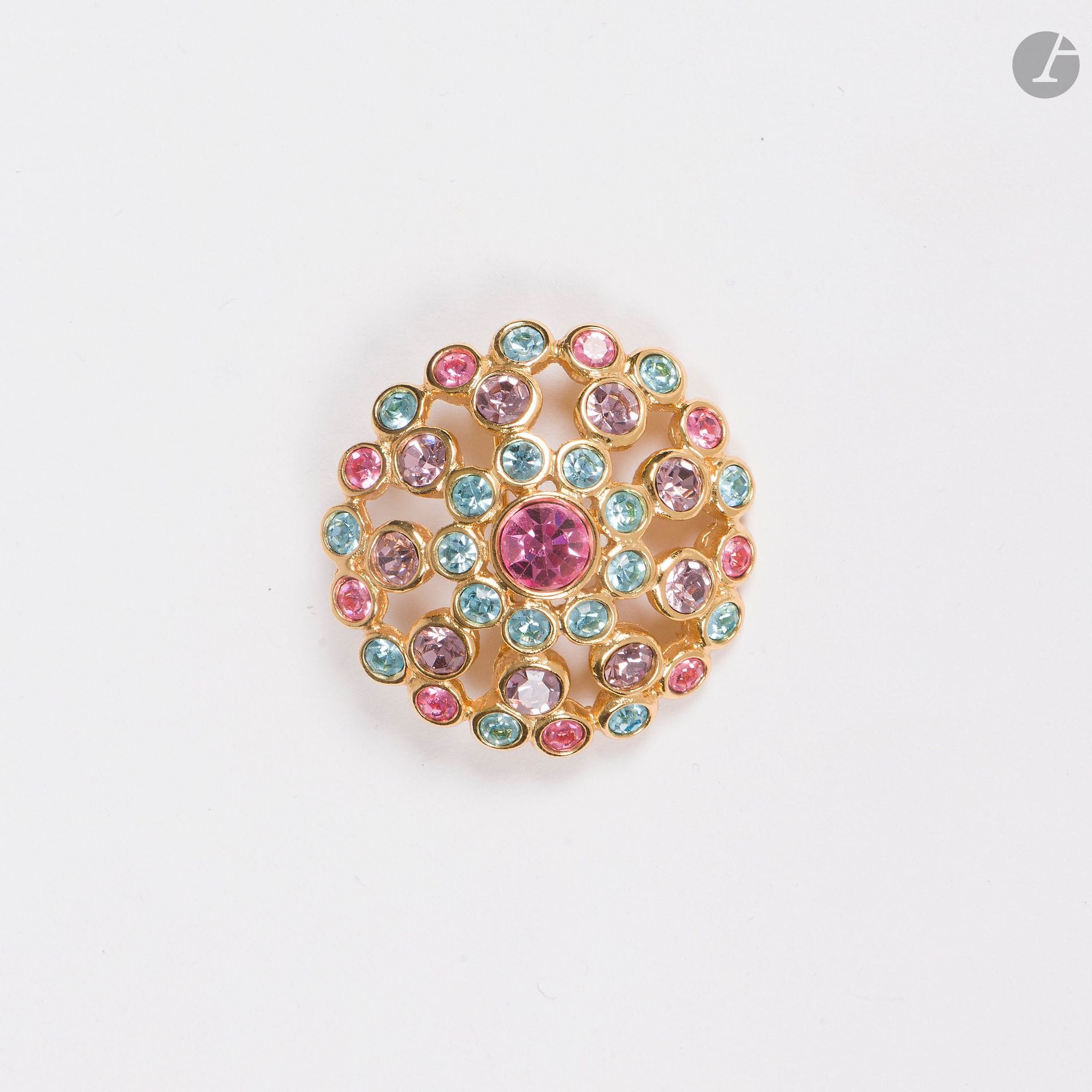 YVES SAINT LAURENT
Round brooch in gilded metal set with colored stones in pastel tones. Signed. Height: 4.3 cm