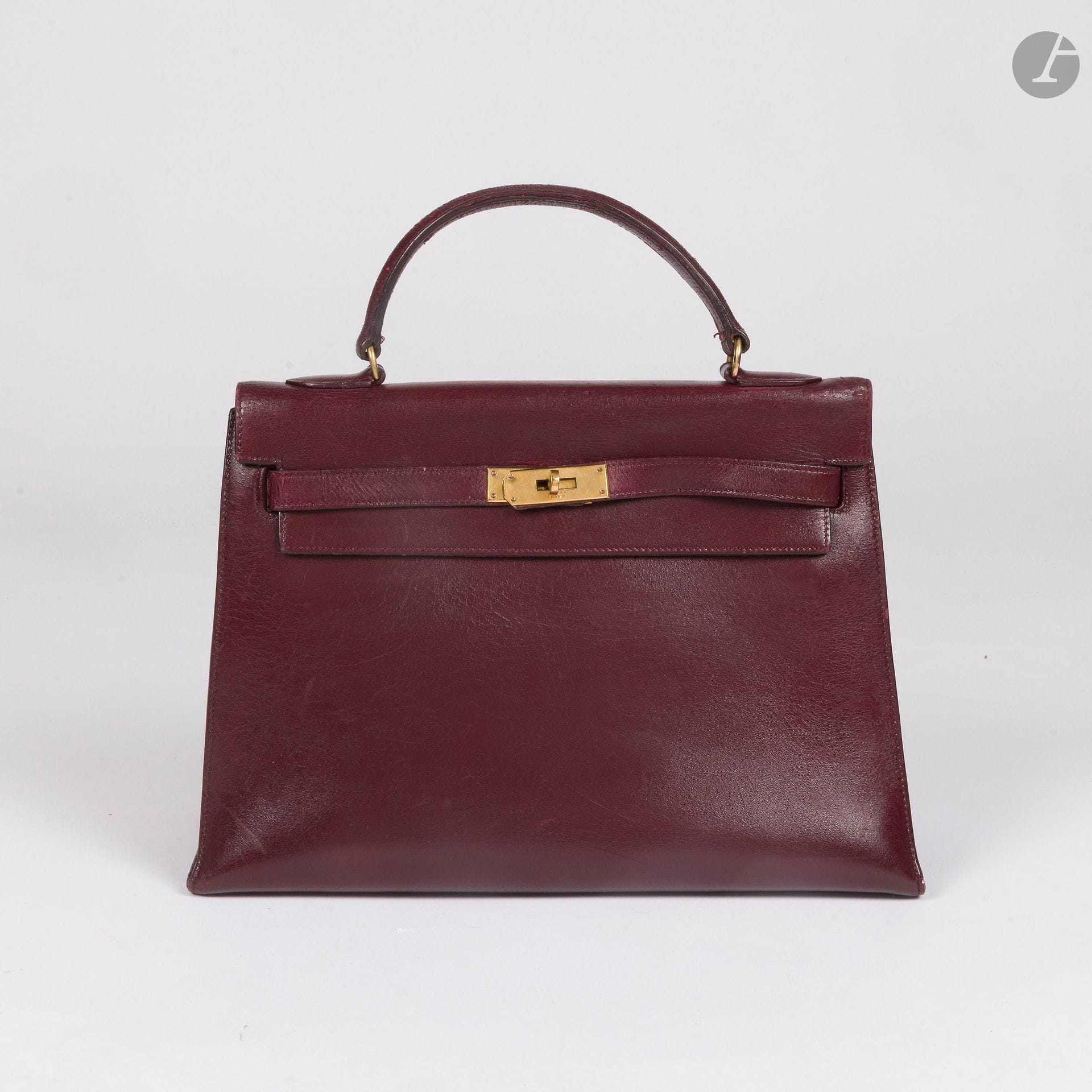 HERMÈS PARIS
Sac KELLY SELLIER 32 en cuir bordeaux, garniture en métal doré
33 x 23 x 13 cm
(entièrement reteint, nombreuses restaurations, craquelures et griffures, touret à revoir, manque clochette cadenas et clés)