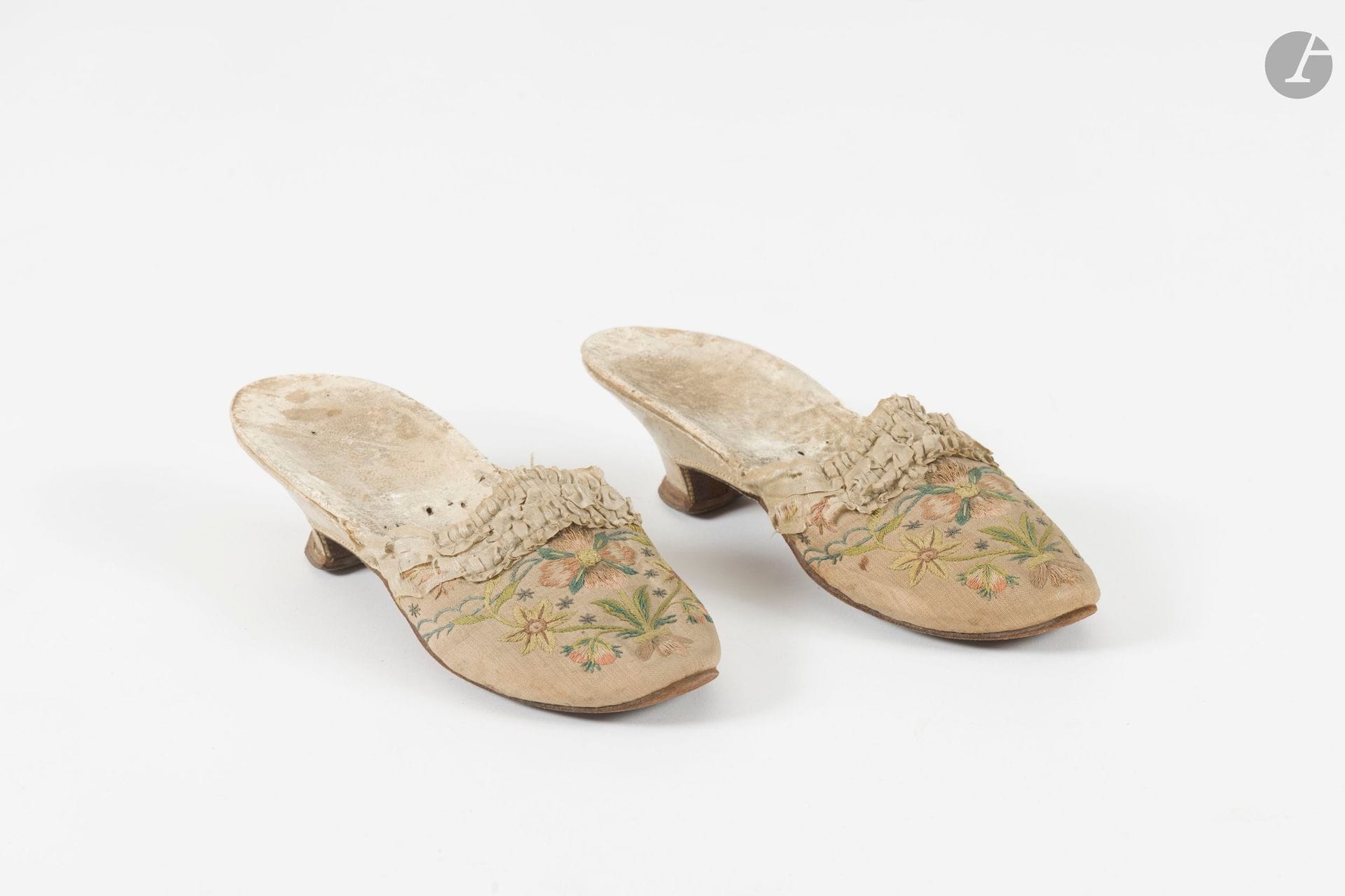 Paire de mules, XVIIIème siècle, époque Louis XVI, empeigne en toile crème brodée de fleurs polychromes au passé plat et bordée d'un ruché, petit talon gainé de cuir blanc (usures)