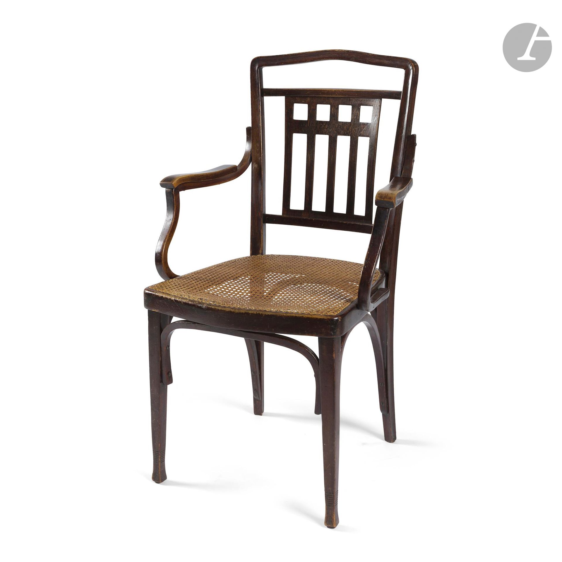 JACOB & JOSEF KOHN VIENNE 
329 F/1, au catalogue commercial de la firme de [1911-1912]
Fauteuil. La structure en bois étuvé, courbé et teinté acajou ; le centre du dossier recevant une plaque en contreplaqué thermoformé aux motifs géométriques ajourés. L’assise à fond de canne. État d’usage, décolorations, le cannage refait. Marqué J.J. KOHN à l’intérieur de la ceinture de l’assise. H.99 cm – L.58 cm – P.51 cm 

Bibliographie : 
Jacob & Josef Kohn of Vienna : Catalogue, 1911-1912 – Catalogue commercial de 1911-1912. Un modèle identique référencé et reproduit page 19.