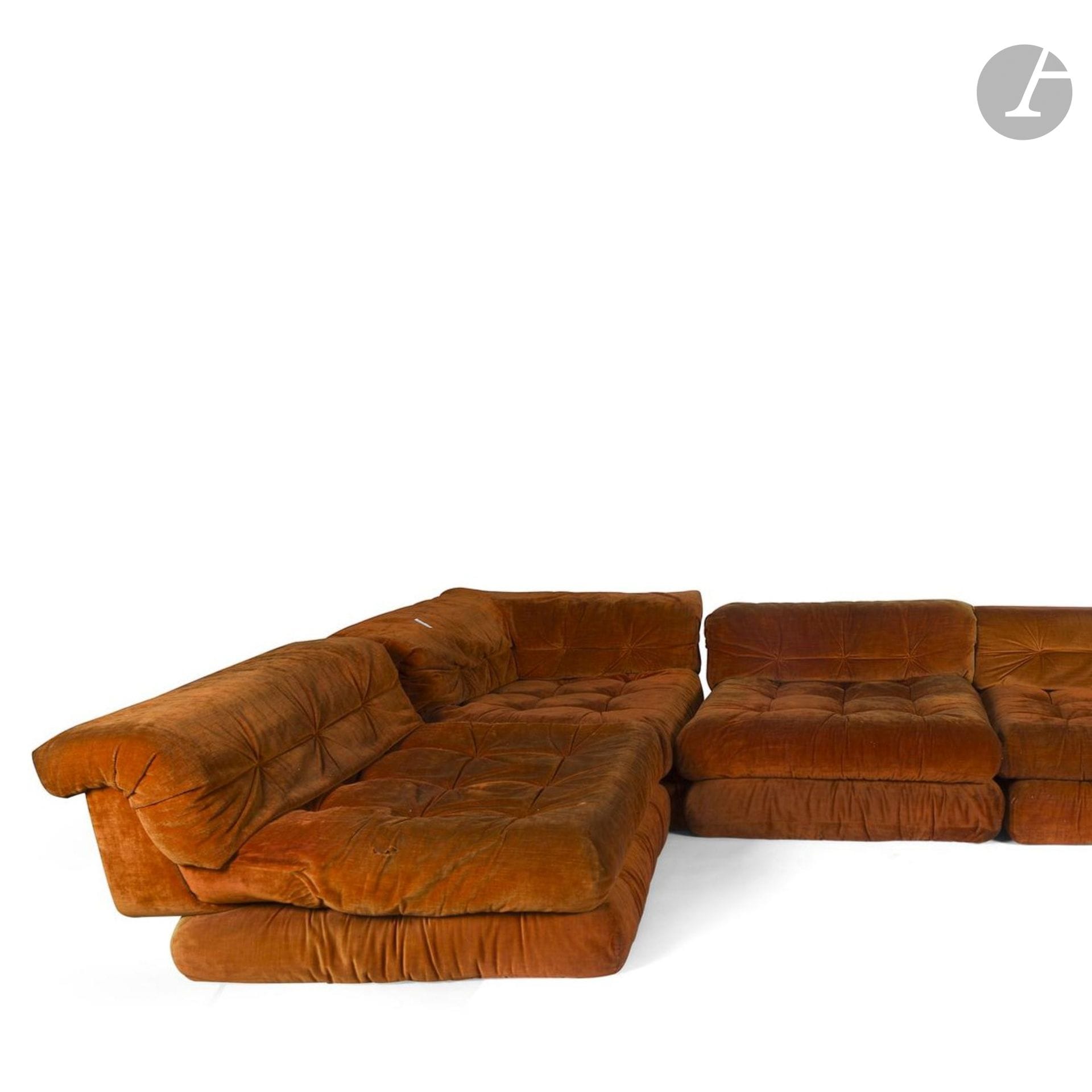 HANS HOPFER (1931-2009) DESIGNER & ROCHE BOBOIS ÉDITEUR 
Mah Jong, le modèle créé en [1971]
Important ensemble de salon modulable pouvant former canapé d’angle, composé de trois chauffeuses, une chauffeuse d’angle et un grand ottoman. Chaque élément garni et tapissé de velours rouille d’origine. Usures, déchirures et manques aux tapisseries. Chaque base au jaconas marqué ROCHE BOBOIS. Les chauffeuses : H.60 cm – L.98 cm – P.98 cm – L’ottoman : H.35 cm – L.98 cm – P.98 cm