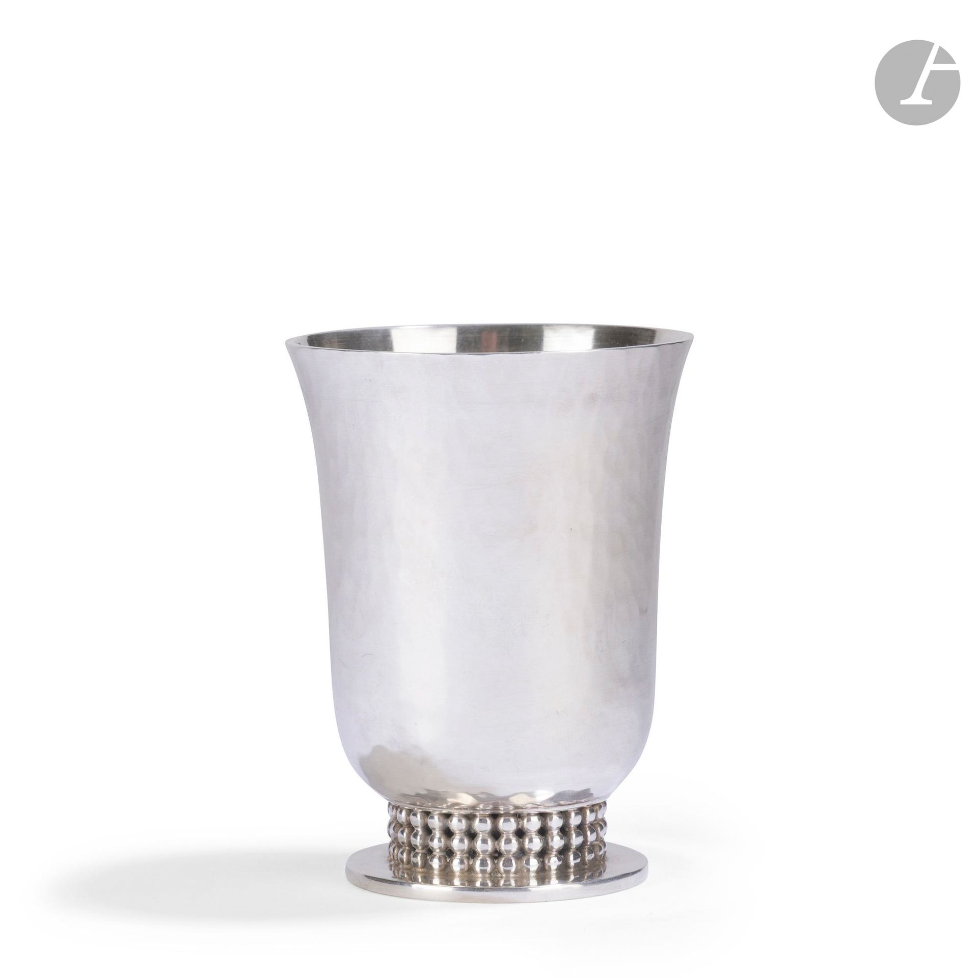 JEAN DESPRÉS (1889-1980)
Timbale en métal argenté ; la surface traitée en martelage. La base circulaire reçoit un ornement de trois rangs perlés. Signée J. DESPRÉS à lapointe sous la base. H.9 cm
