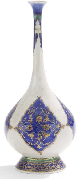 Flacon en céramique au médaillon polylobé, France, Manufacture de Samson, fin XIXe siècle Céramique à panse globulaire sur petit piédouche, à long col évasé. Décor de mandorles polylobées cobalt de rinceaux de palmettes dorées se détachant sur un fond blanc. Sur le pied, frise de rinceaux dorés sur fond bleu, bordée d?un cordon turquoise. H.: 21,5 cm A glazed pottery vase, France manufactured by Samson, end of 19th century