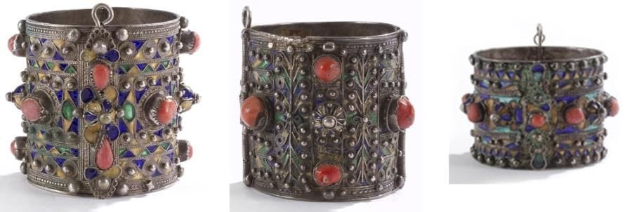 Trois bracelets articulés, Algérie, Grande Kabylie, Beni Yenni, début du XXe siècle Argent émaillé en polychromie et cabochons de corail d?un décor de frises géométriques polylobées. Diam.: 6,5 cm, 6 cm et 6 cm Three silver bangles, Algeria, Great Kabilya, early 20th century