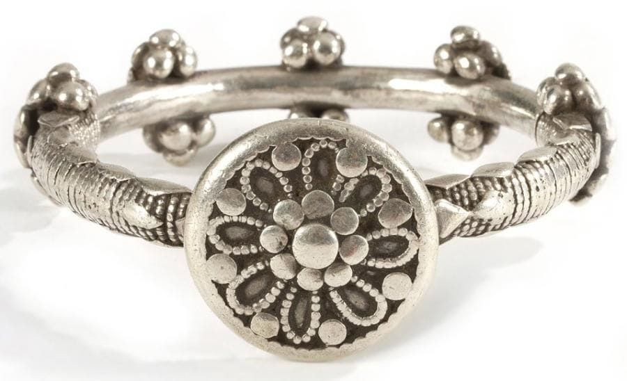 Bracelet au large disque, Yémen, XXe siècle Anneau en argent rehaussé de grappes de perles et d?un large disque à rosette formée de petites perles aplaties. Diam.: 8 cm Poids: 128 gr A silver bracelet with a broad disc, Yemen, 20th century