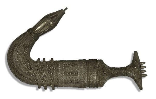 Poignard jambiya, Yémen, XXe siècle Lame courbe en acier damassé, à monture en argent à décor filigrané et appliqué de rosettes, de frises géométriques, et coiffée de quatre petits cônes. Fourreau en argent à décor également filigrané et appliqué de frises géométriques. Six attaches en anneau. L.: 32,5 cm Dagger, Jambiyya, Yemen, 20th century