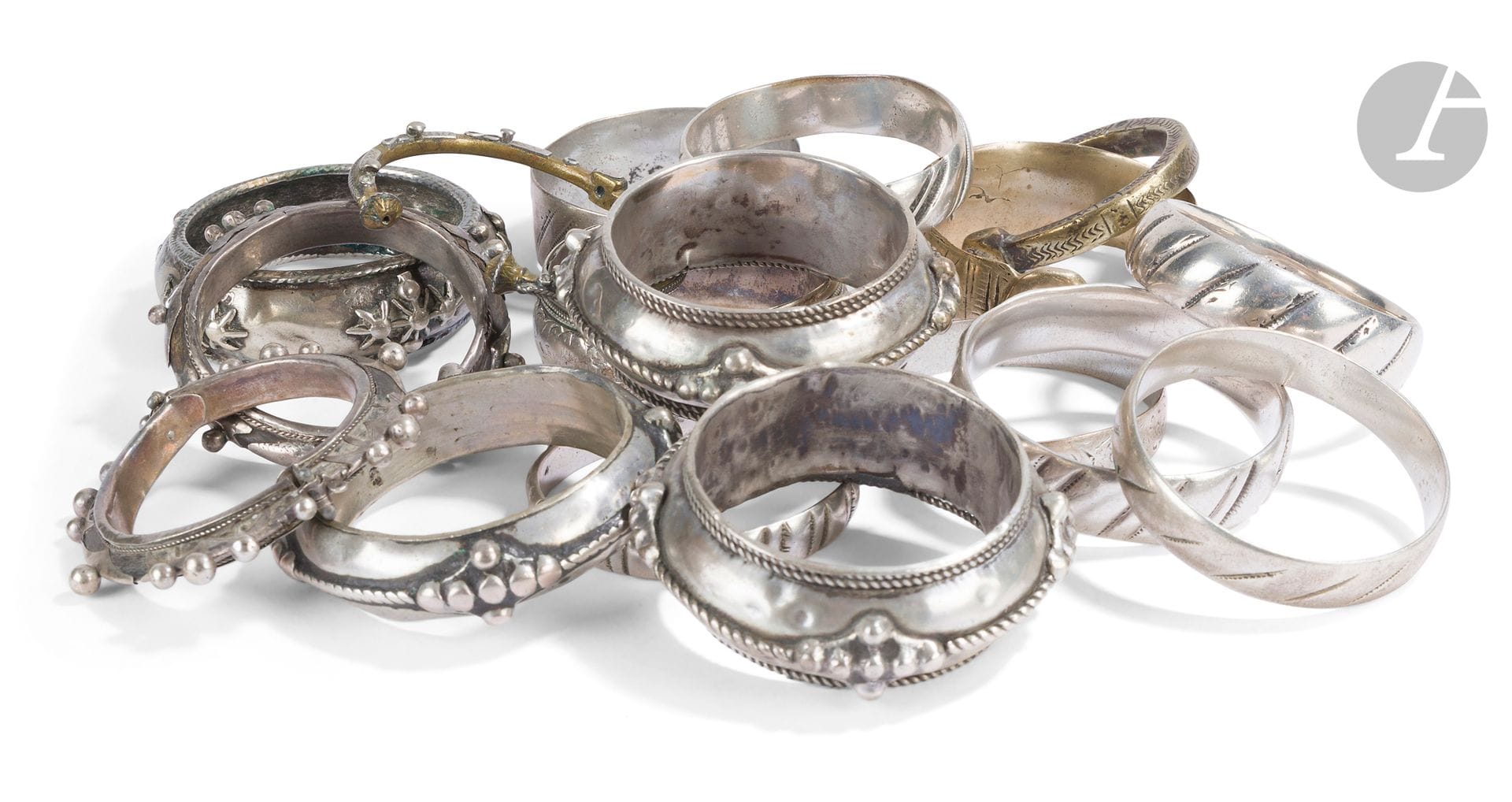 Fort lot de bracelets, Afrique du Nord et subsaharienne, XXe siècle
Ensemble de dix-sept bracelets annulaires et manchettes en argent (sept) et métal (dix), à décor géométrique, pour certains moulé, pour d’autres ciselé ou appliqué de clous. Sur l’ensemble, plusieurs paires ou pouvant former paires, trois bracelets ouverts et deux en bois gainés d’argent.
D. intérieur : entre 5,1 et 8,9 cm ; PB argent : 545 g ; PB métal : 506 g
Petits accidents et traces d’oxydation.