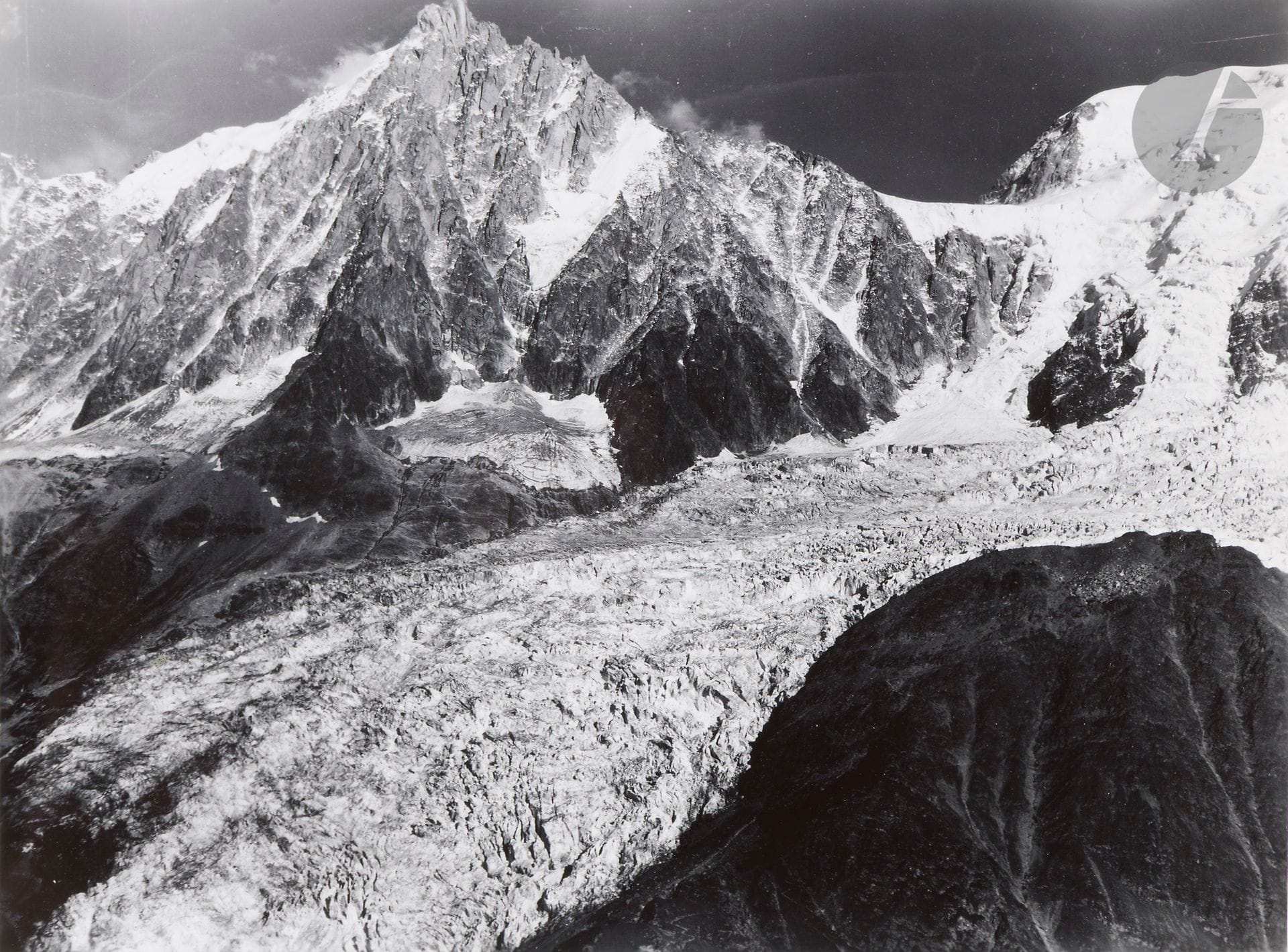 Roger Henrard (1900-1975)
Photographie aérienne. Alpes, c. 1950. 
Massif du Mont-Blanc. Vallée de Sallanches. Aiguilles de Varan. Mer de Glace. Glacier des Bossons. Aiguille du Midi. La Verte et les Drus. Vallée des Contamines. Dôme de Miage. Verticale de Megève. Vallée de Chamonix. Les Grandes Jorasses. Glacier du Tour. Glacier d’Argentière. Le Charvin.
Album in-4 oblong composé de 49 épreuves argentiques d’époque, contrecollées sur cartons. Nombreuses légendes manuscrites dans les marges des épreuves. Tampon « Pilote et opérateur R. Henrard - Avion utilisé « Norécrin » » aux versos des épreuves. 
Format moyen : 18,5 x 24 cm avec marges
