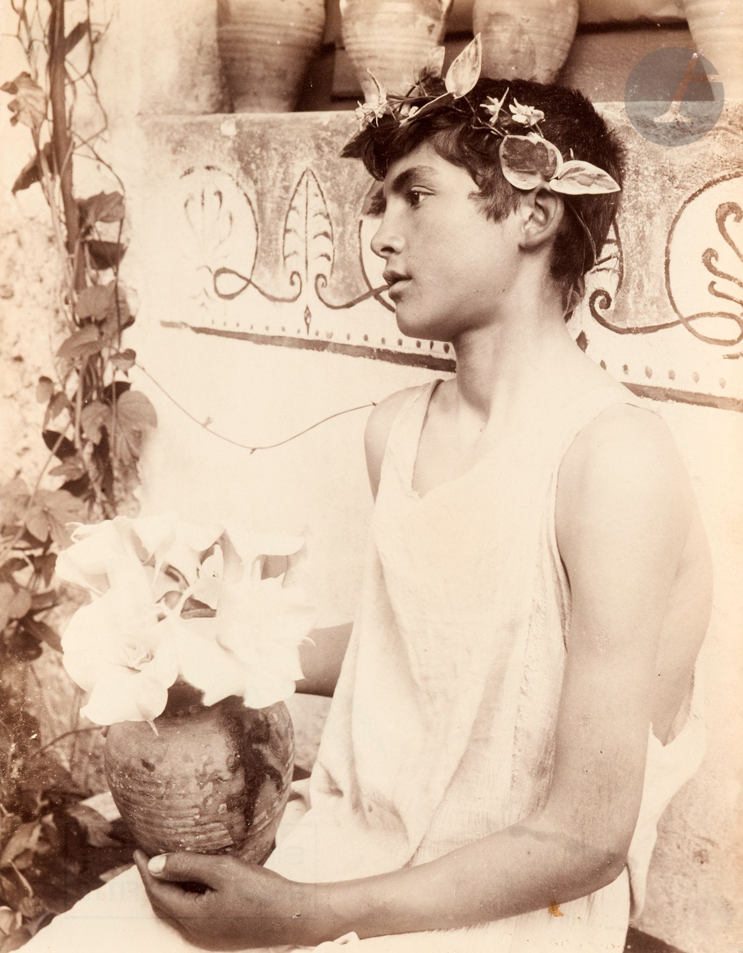 Wilhelm von Gloeden (1856-1931)
Jeune sicilien [Giacomo Lanfranchi] à la couronne de fleurs et au pot de daturas. Taormina, Sicile, c. 1895. 
Épreuve sur papier albuminé. Tampons « W. v. Gloeden - Kunstverlag - Deponirt Oct. 1902 - Taormina Sicilia » et « Bibliothèque - Roger Peyrefitte » avec numéro de négatif « 1747 » au crayon bleu au verso.
21,3 x 17 cm

Provenance : 
Ancienne collection Roger Peyrefitte.