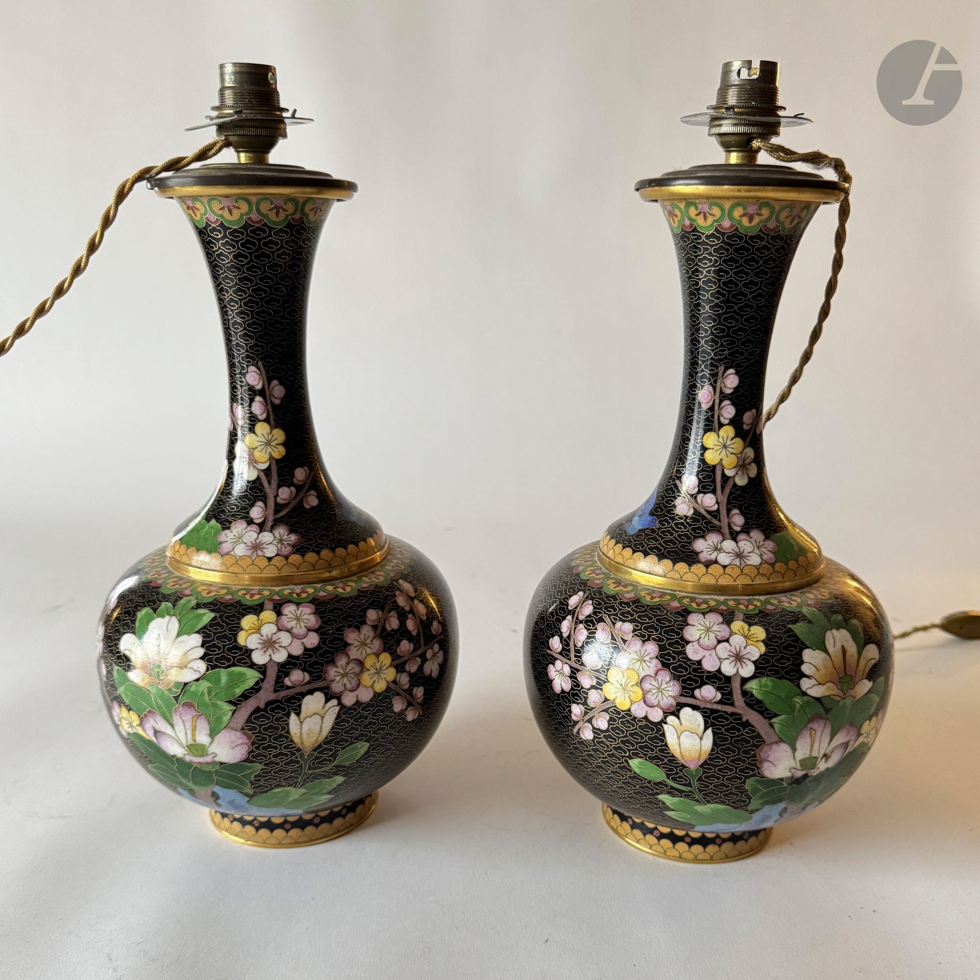 CHINE
Paire de vases cloisonnés montés en lampe sur fond noir à décor de fleurs et oiseaux.
XXe siècle.
H. : 32 cm, L. : 17 cm. 
Avec des socles en bois.