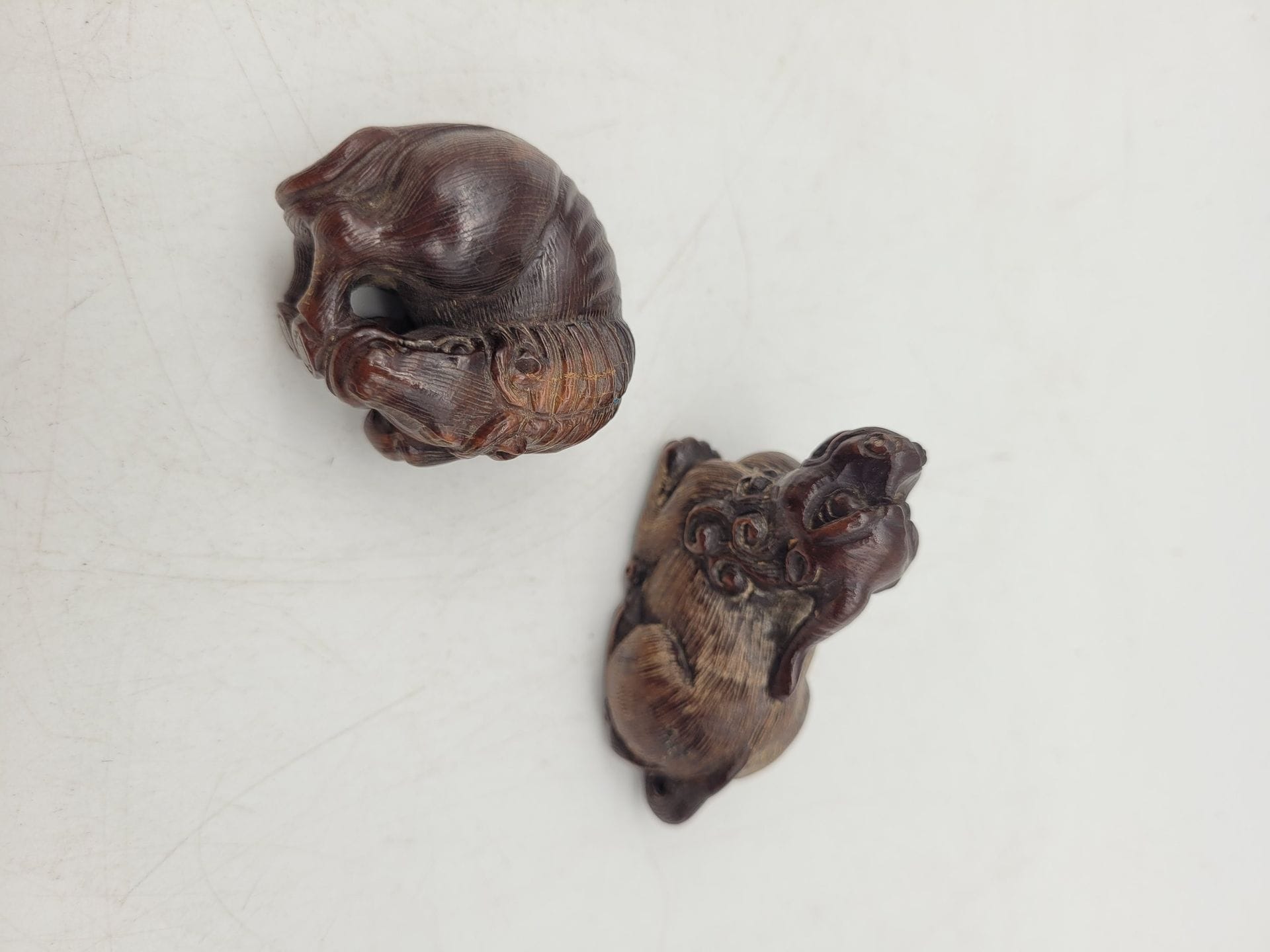 Deux netsuke en bois, Japon, époque Showa (1926-1989)
- L'une représentant un animal mythique unicorne dans le style de l'animal légendaire chinois pixiu. - L'autre représentant un cheval la tête tournée vers l'arrière se mordillant le sabot arrière droit. Les deux sont signés Gyokuishi - ??.
3,5 x 4,8 et 3,5 cm