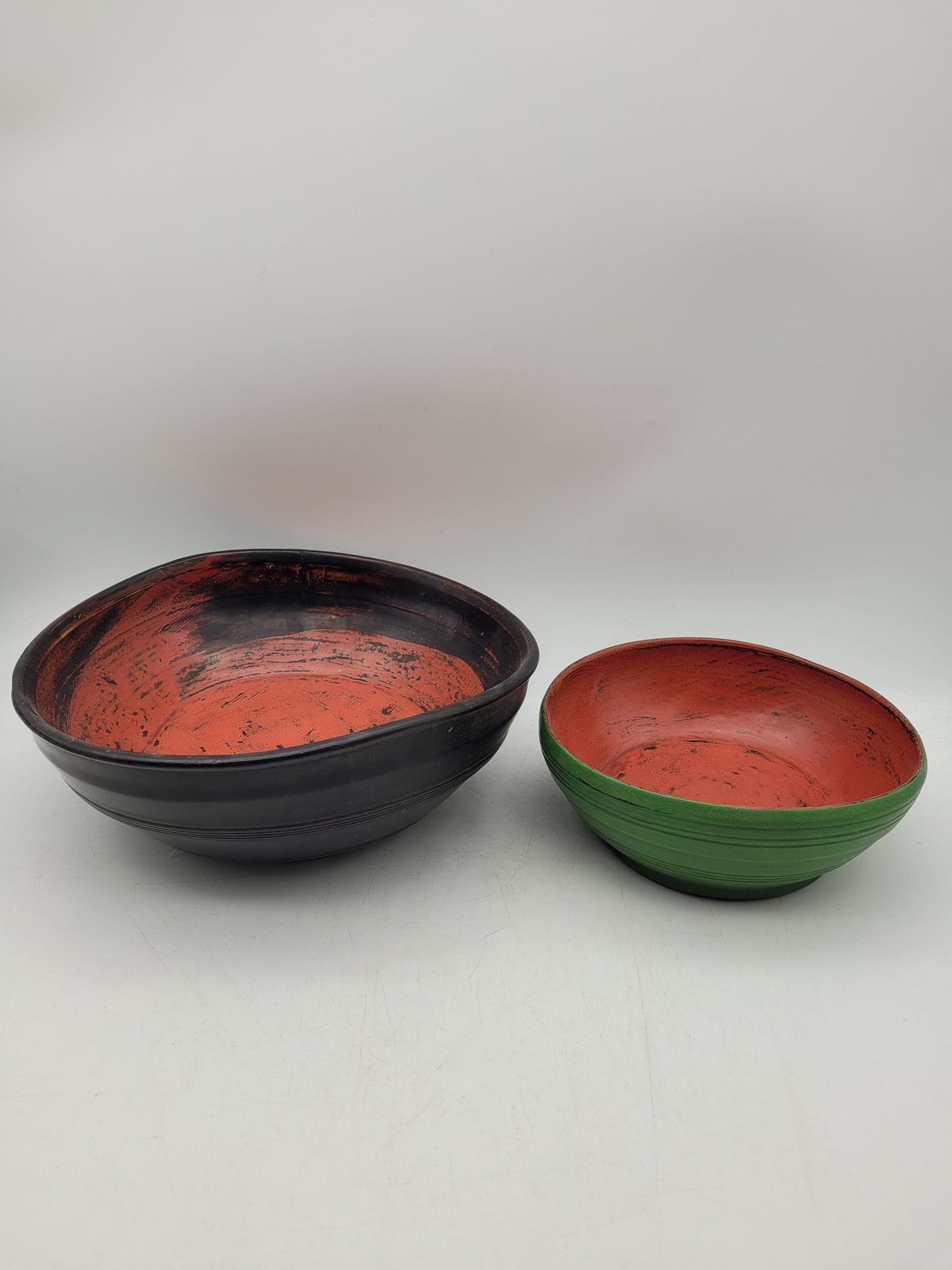 Van Minh NGUYEN (1930-2014) 
Deux bols en bois laqué, l’un vert et rouge, l’autre noir et rouge. 
Diamètres : 22 cm et 31,5 cm