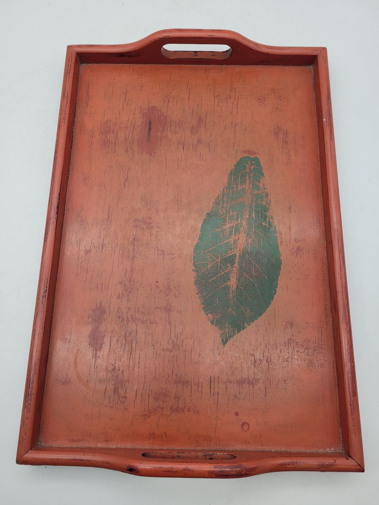 Van Minh NGUYEN (1930-2014) 
Lacquered wood tray with red background decorated with a green leaf.
49 x 33 x 6 cm