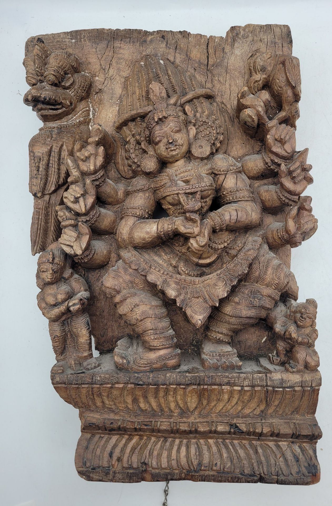 Bois de char sculpté, peut-être Inde du Sud, Tamil Nadu, XVIIIe siècle
Panneau de bois sculpté, gravé et ajouré d'une figure de déesse, vraisemblablement Mohini, avatar féminin de Vishnou accompagné du véhicule Garuda, d'un aigle et de deux figures humaines. 
52 x 31,6 cm 
Quelques fissures, réparations à la colle, usures, chaînes fixées au dos.