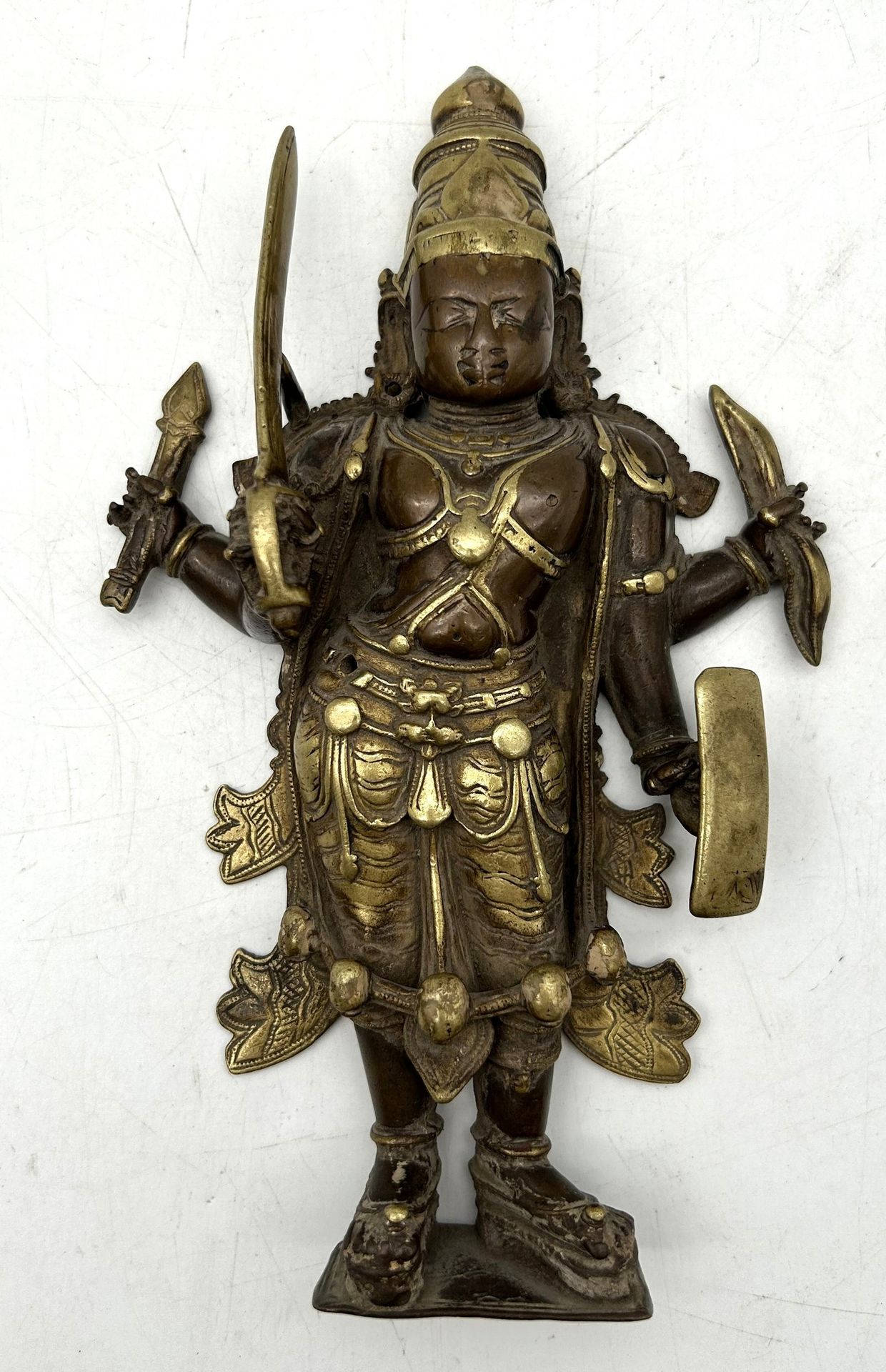 Shiva Virabhadra in copper alloy with two patinas in hollow high relief, India 
Forming a sconce, in warrior form, holding a sword, shield, bow and arrow. 
Height: 20.5 cm 
Old repair to one arm.
