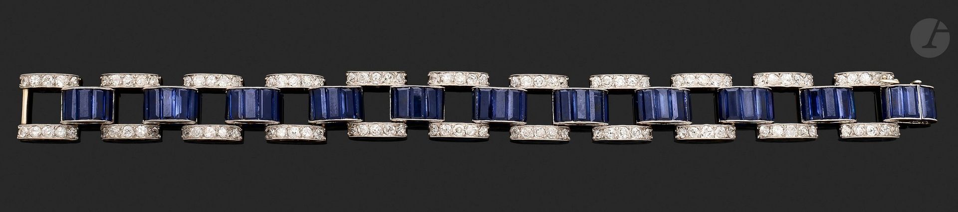 Bracelet in platinum and 18K (750) white gold, articulated with bars set with round old-cut diamonds, alternating with bars set with synthetic sapphires. Dimensions: approx. 18x1.3cm. Gross weight: 28.6g