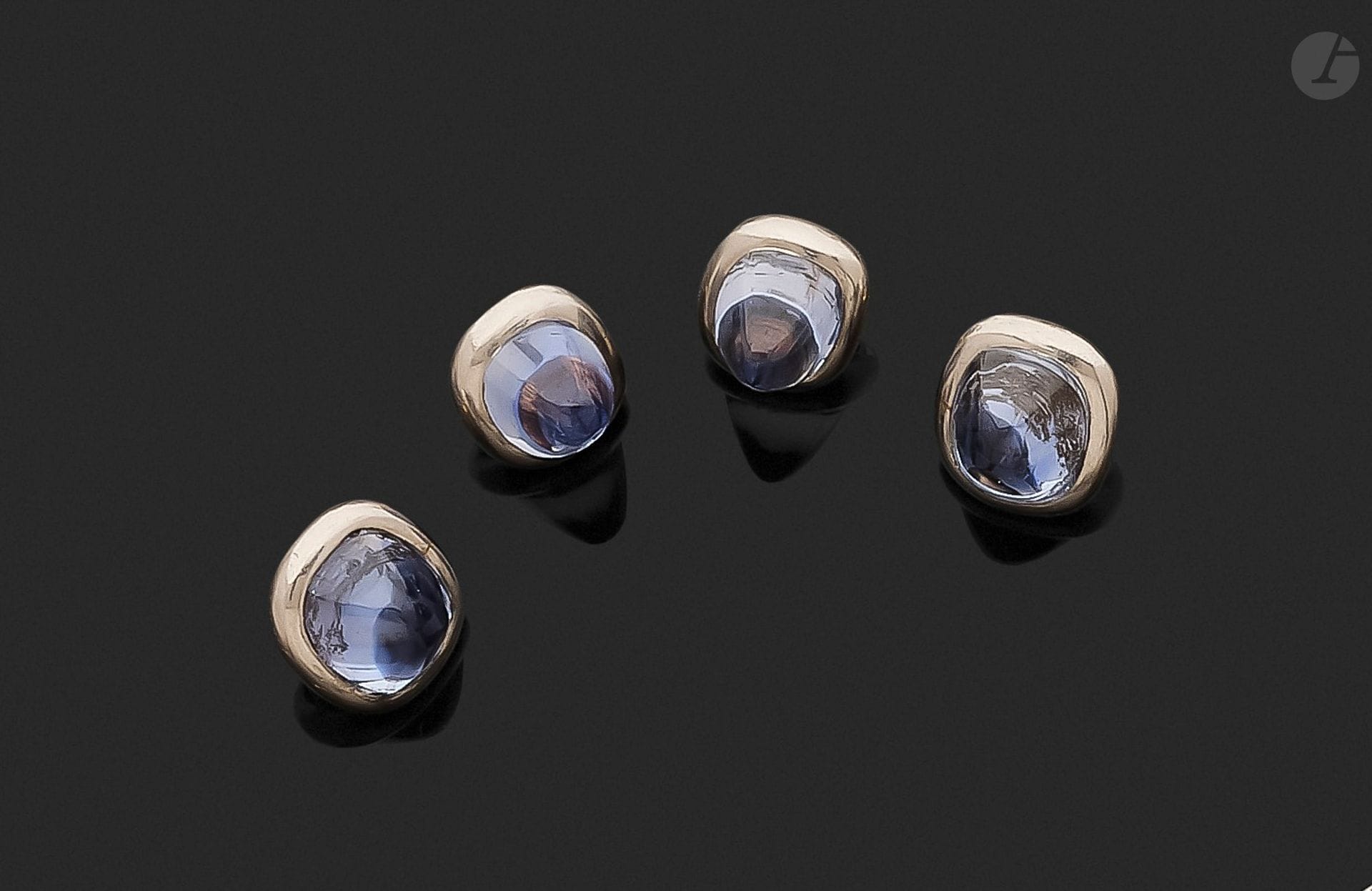 Suite de 4 boutons en platine et en or 18K (750), chacun serti d’un saphir cabochon. Travail des années 1925. Dimensions d’un saphir: 8,5x7,2 mm environ. Poids brut: 7,9g