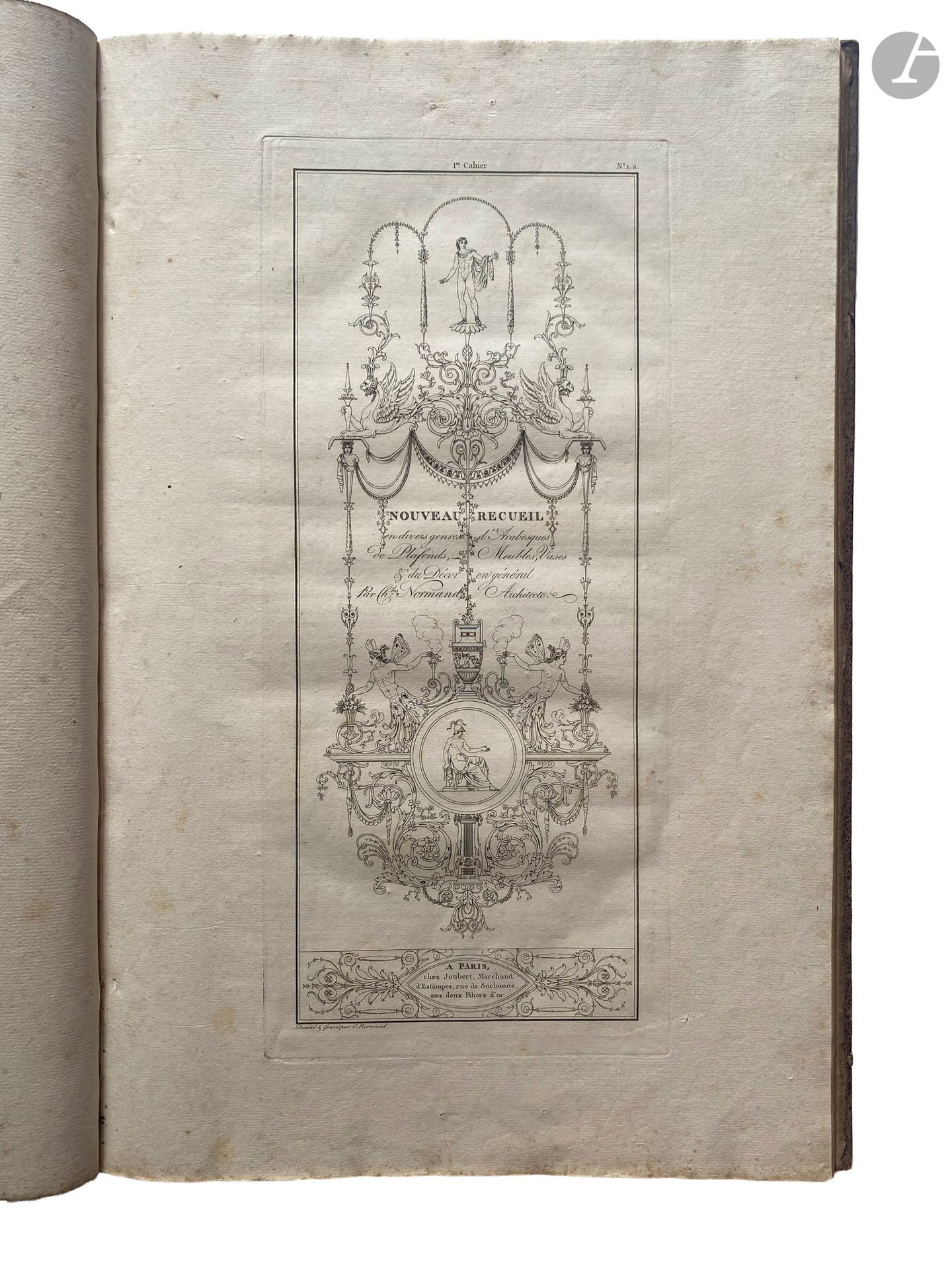 NORMAND (Charles).
Nouveau recueil en divers genres d'ornemens et autres objets propres à la décoration ; tels que : Panneaux, vases, plafonds, candélabres, autels, trépieds, cassolettes, sarcophages, coupes, frises, camées, bas-reliefs, masques, lits, chaises, fauteuils, bergères, tables, bureaux, secrétaires, autres meubles, etc., etc.
Paris : Joubert, An XI-1803. — In-folio, cartonnage papier moucheté, dos lisse, tranches jaunes (reliure de l'époque).
Édition originale de ce recueil de Charles Normand (1765-1840), architecte et artiste incarnant le passage du néoclassicisme au style Empire, collaborateur notamment de Percier et Fontaine.

Il s'agit d'un véritable catalogue d'ornements caractéristiques de l'époque, se composant, outre des feuillets de texte, d'un titre gravé et de 35 planches dessinées et gravées au trait par Normand.

Exemplaire enrichi, comme c'est souvent le cas, du « Premier [et deuxième] Cayer de Panneaux, Frises et sujets Arabesques. Composés et Gravés par Fr. M. Queverdo » (1748-1797), composés de 12 planches dessinées et gravées par ce dernier en 1788 et publiés par Chéreau et Joubert.

Frottements et quelques déchirures au cartonnage. Rousseurs. La date de « 1803 » a été grattée sur le titre.