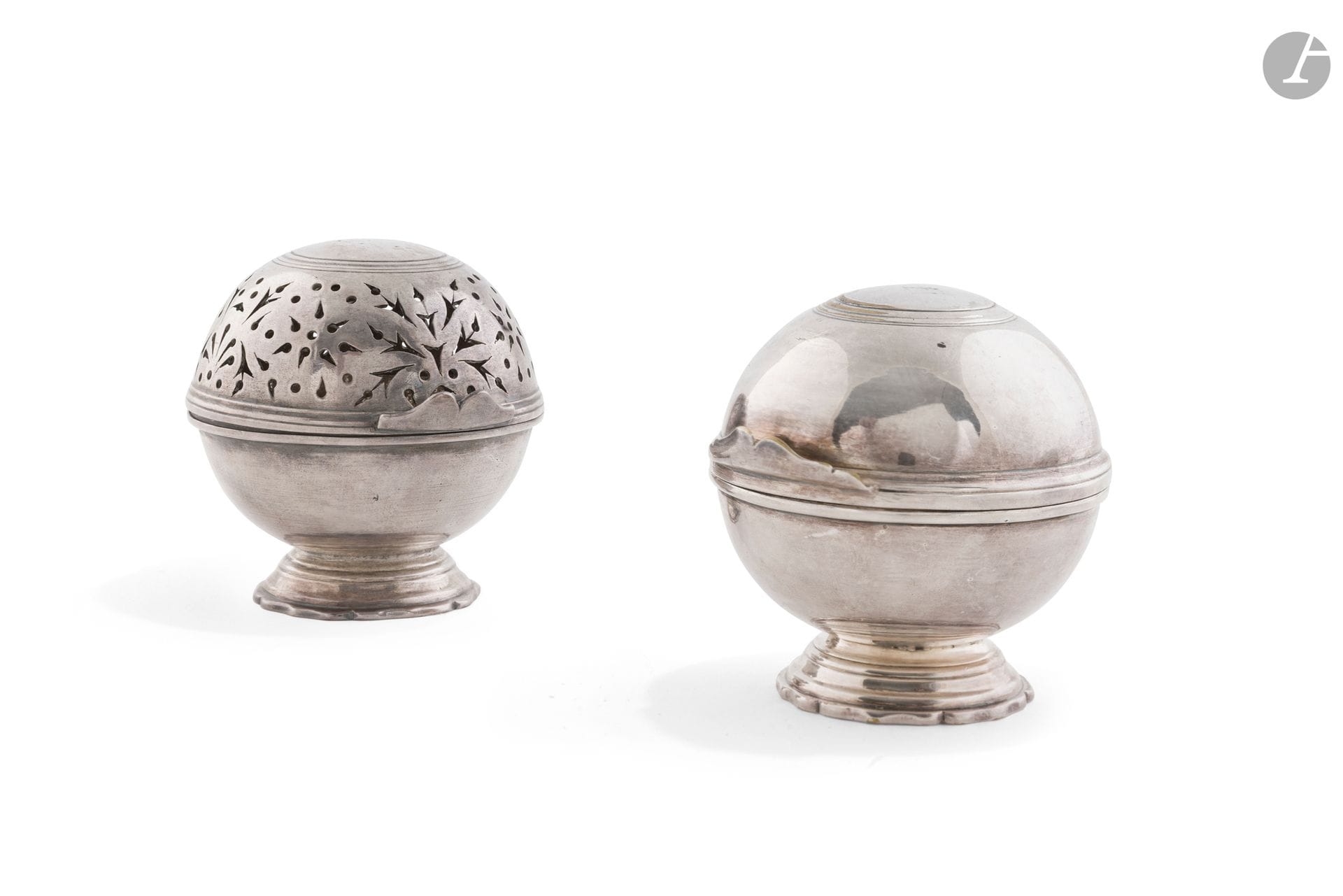 FRANCE XVIIIe siècle
Paire de boules à éponge et à savon en laiton argenté anciennement plaqué. Elles reposent sur un piédouche polylobé, le couvercle à charnière, le repercé s'articule autour de motifs de tulipes, larmes, palmettes et marguerites.
Hauteur : 9 cm
État : manque une goupille à la charnière de la boule à savon