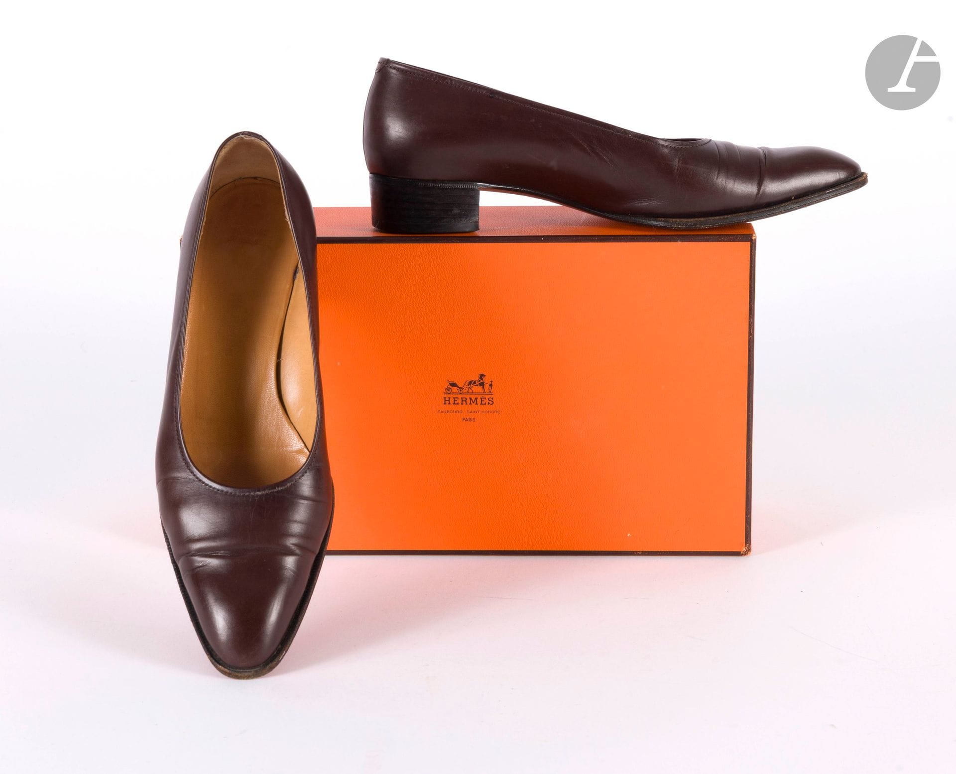 HERMÈS PARIS
Deux paires de souliers : une paire d'escarpins en cuir marron et une paire de mocassins à talons en cuir bordeaux avec fermoir bâton en métal à l'empeigne. T.36,5 indiquées. Dustbags et boîtes
(traces d'usage)