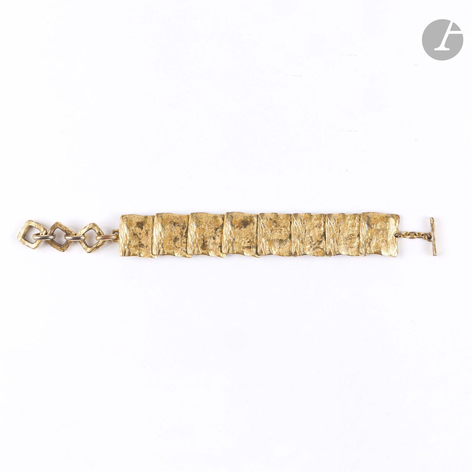 YVES SAINT LAURENT
Bracelet articulé en métal doré travaillé. Signé. L : 21 cm
(pertes de dorure)