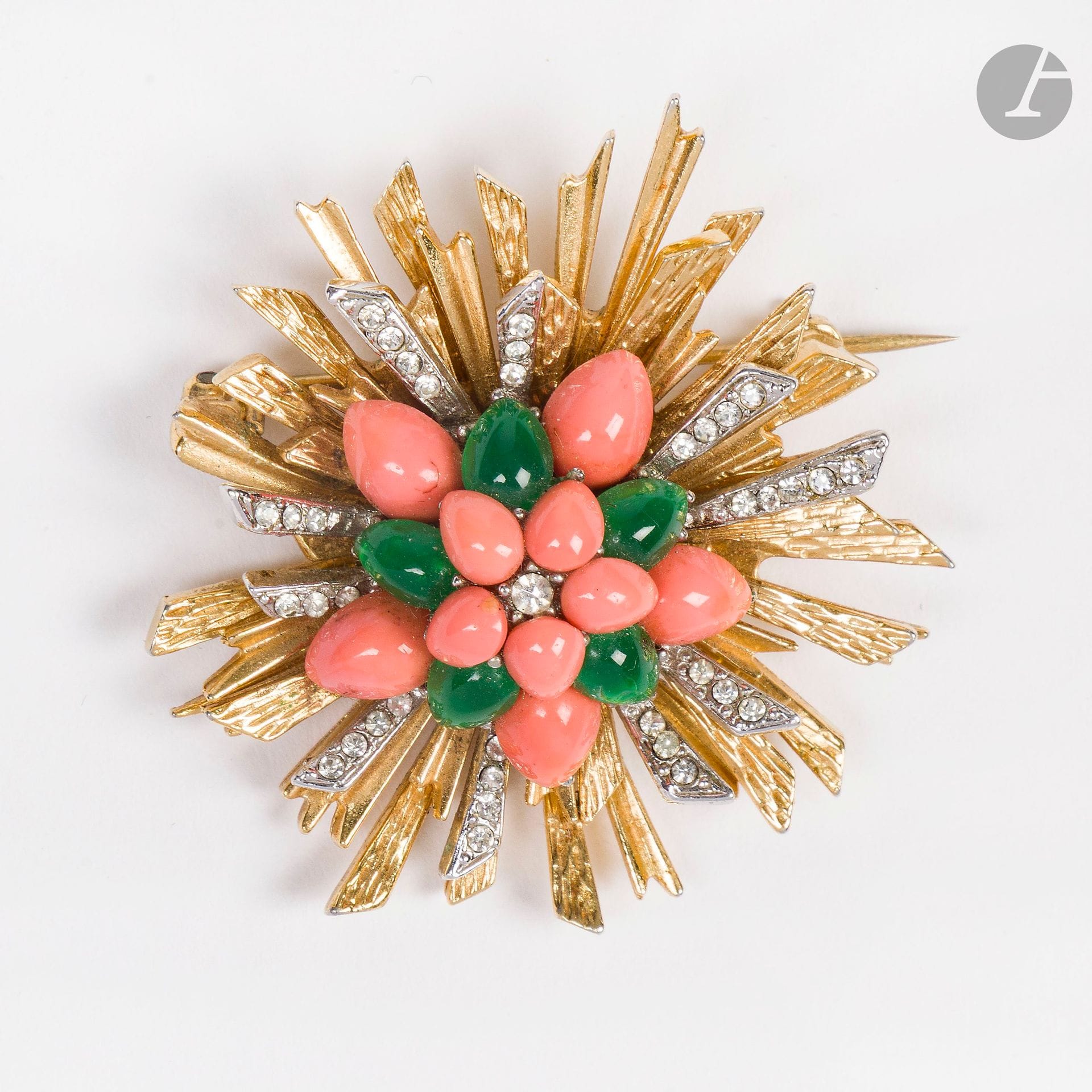 CARVEN
Gold and silver-plated metal brooch with radiant motif, rhinestones, coral and green pearls. Signed. H: 5 cm (a tiny chip in a coral bead, two holes in the metal back)