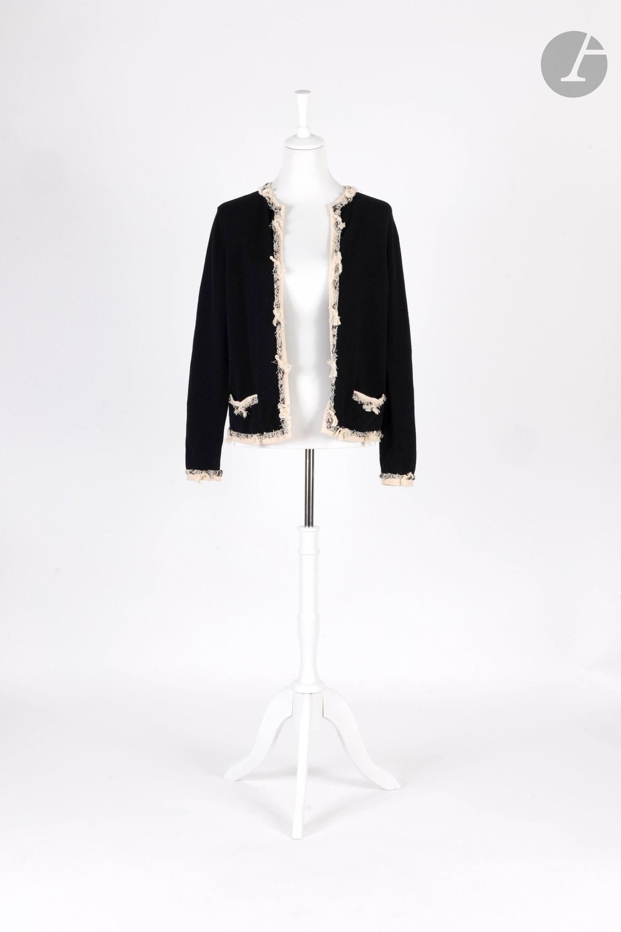 CHANEL
Black cashmere cardigan with beige piping and trimmings in black and beige tones. S.44 shown may correspond to a 40 approx.
(a very small hole at the base of the right shoulder)