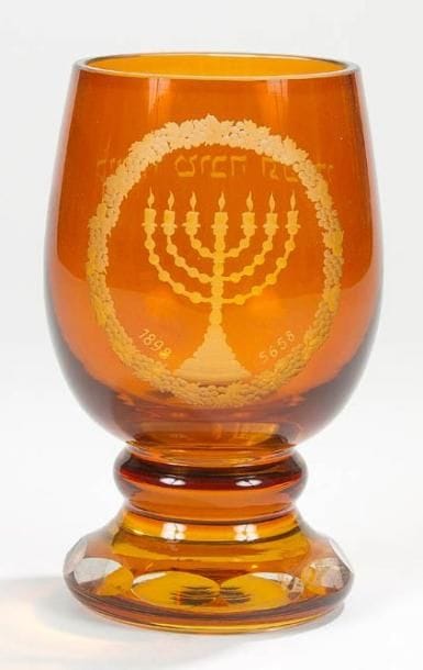 VERRE DE BOHÊME de Rosh Ha-Shanah (Nouvel an) à fond orangé, gravé à la roue d'une menorah dans un médaillon de grappes de raisins et daté 1898 (5658), en vis-à-vis et gravé en hébreu du souhait: soyez inscrits pour une bonne année. Bohème, fin du XIXe siècle. Hauteur: 15,5 cm