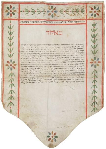 [MANUSCRIT - KETOUBA] Contrat de mariage manuscrit enluminé sur parchemin établi à Rome en 1852  Isaac fils de Yossef Baroukh SERMONETA et Judith fille de Masliah FIANO. Document décoré d'une guirlande de fleurs polychromes. Restaurations et rousseurs, découpé en pointe sur le bord inférieur. 80 x 56 cm