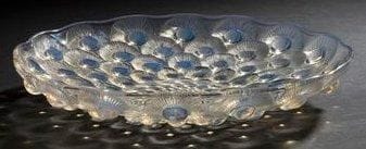 RENE LALIQUE (1860-1945)
Plumes de paon, modèle créé le 11 juin 1932 Coupe creuse à bord festonné. Épreuve en verre opalescent moulé pressé. Signée R. LALIQUE France en lettres cursives sous la base. Diamètre: 30 cm Bibliographie: «R. Lalique, catalogue raisonné de l?oeuvre de verre» par Félix Marcilhac. Éditions de l?amateur. Paris 2004. Modèle identique reproduit page 305 et référencé sous le numéro 10-377.