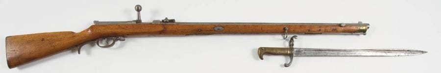 Allemagne
Fusil de fusilier Dreyse modèle 1860 à verrou, calibre 13,6 mm. Canon rond à pans au tonnerre, avec hausse, marqué «Stahl». Boîte de culasse marquée «F.G. Mod 1860» et datée 1861 et 1863. Garnitures en laiton poinçonné. Plaque de couche en fer avec marquages «3 57 F.R. 35». Crosse en noyer. Baguette en fer. Avec une baïonnette au modèle avec arête ramenée à la pointe. Matriculée «F.R. 35. 7. 39.». S.F. (Lame piquée). B.E. Longueur arme: 130 cm Longueur baïonnette: 62 cm