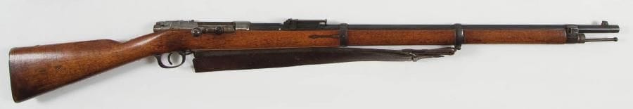 Allemagne
Fusil Mauser modèle 1871-84 à verrou, calibre 11 mm. Canon rond à pans au tonnerre, bronzé, avec hausse à planchette et frappé «ERFURT» sous couronne. Boîte de culasse marquée «Mod 71/84» et datée 1886. Garnitures en fer bronzé. Plaque de couche avec matricule du 118e Régiment d?infanterie. Crosse en noyer. Bretelle en cuir quadrillé. B.E. Longueur arme: 129 cm