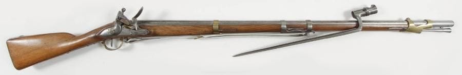 France
Fusil de dragon à silex modèle An IX. Canon rond à pans au tonnerre, daté «1810». Platine à corps plat «Maubeuge Manuf Rle» et chien à corps rond. Garnitures en laiton poinçonné. Grenadière à double bande et plaque de couche en fer. Crosse en noyer clair, à joue. Baguette en fer. Avec une baïonnette à douille au modèle. B.E. Longueur arme: 142,5 cm Longueur baïonnette: 47 cm