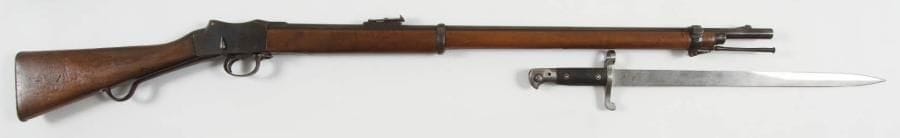 GRANDE-BRETAGNE
Fusil Martini Henry à verrou, calibre 11,43 mm. Canon rond à pans au tonnerre, avec hausse à 1200 yards. Boîte de culasse frappée «V.R.» sous couronne et «EINFIELD 1886». Garnitures et levier d?armement en fer. Crosse en noyer. Baguette en fer. Avec une baïonnette MK III. S.F. A.B.E. Longueur arme: 125 cm Longueur baïonnette: 59,7 cm 5e catégorie