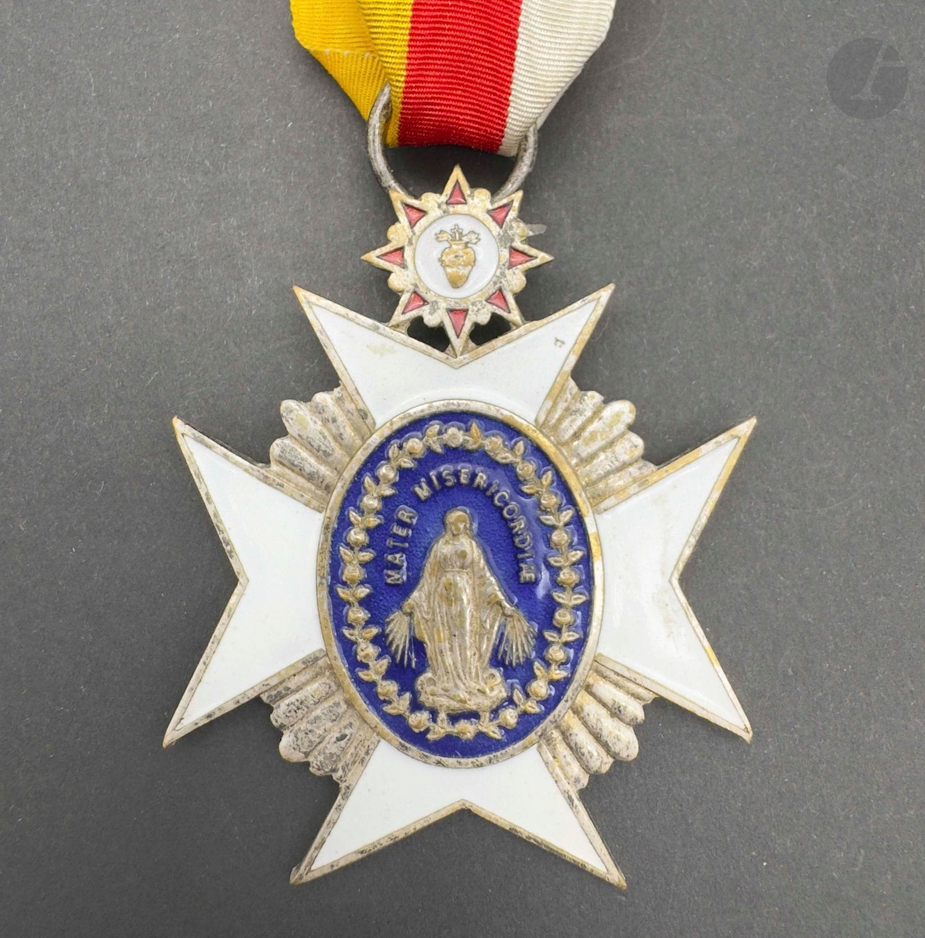 Croix de récompense du diocèse de Fribourg. 
En cuivre argenté et émail. Long ruban en moire. Revers marqué «leo xiii reg friburg mcmii». 
60 x 55 mm 
T.T.B.