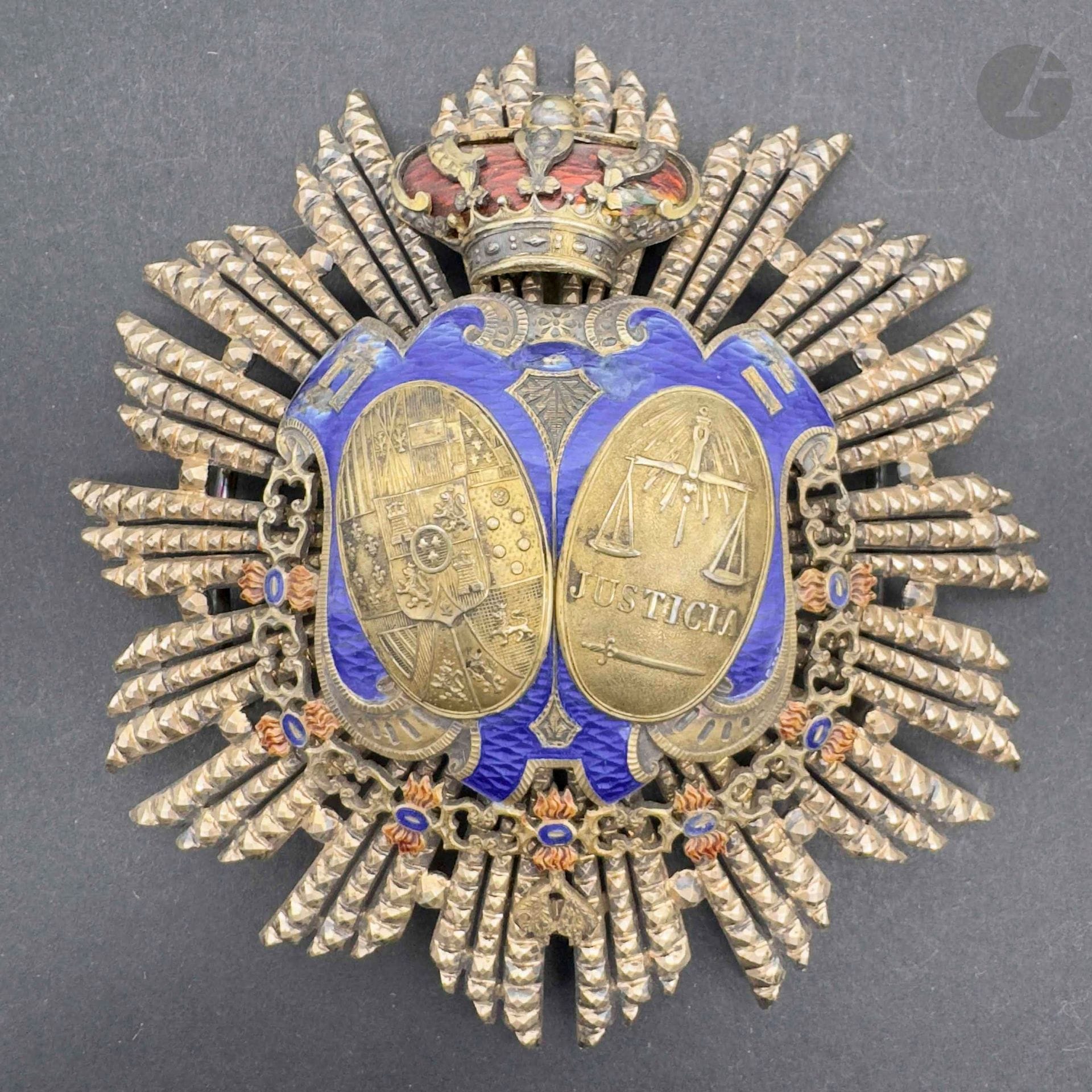 ESPAGNE
Plaque de juge de la cour suprême en vermeil et émail (éclats à l’émail bleu), centre ceint du collier de la toison d’or, surmonté de la couronne royale. Revers à attache basculante et deux crochets. Poinçon tête de sanglier. 
86 mm - Poids brut: 72 g 
T.B. à T.T.B..