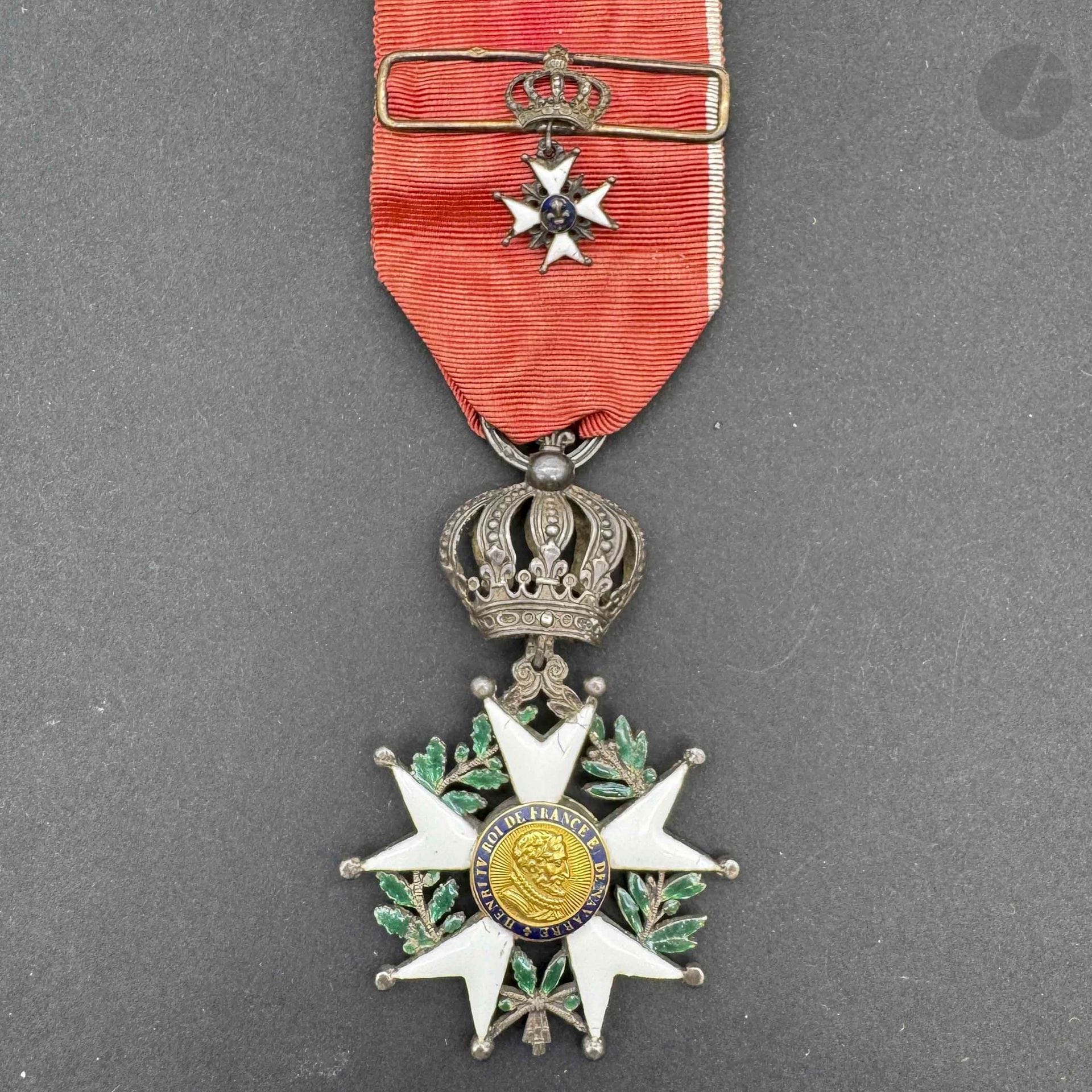 FRANCE 
ORDRE DE LA LÉGION D’HONNEUR 
Étoile de chevalier d’époque Restauration. 
En argent, émail (éclats). Les centres en or émaillé. Chevalet et attache à la couronne modifiés. 
Long ruban à liseré blanc avec barrette ajourée à la croix du lys émaillée. Traces de poinçon. 
Anneau cannelé. 
70 x 44 mm - Poids brut: 16,5 g 
B.