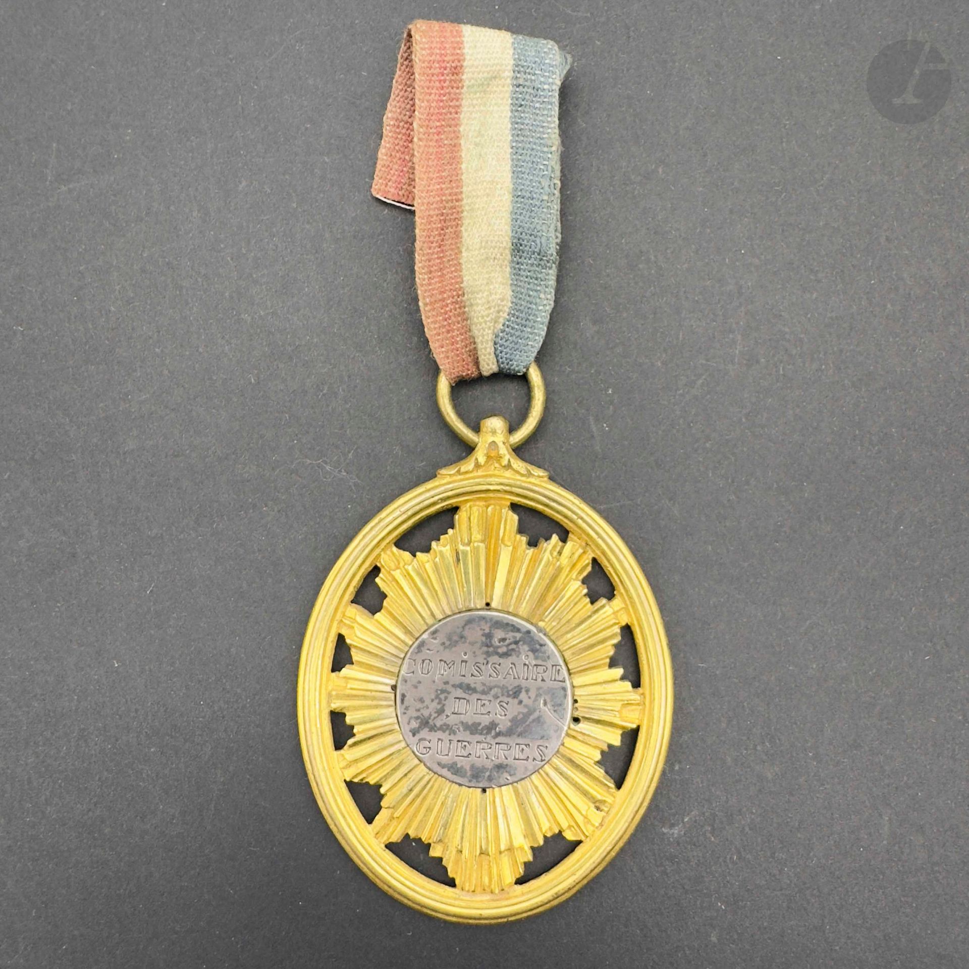 FRANCE 
Chased bronze, gilt and openwork commissioner of wars medallion with silver center engraved with "la loi" on one side and "comissaire des guerres" on the other. Later tricolor ribbon. 
57 x 43 mm