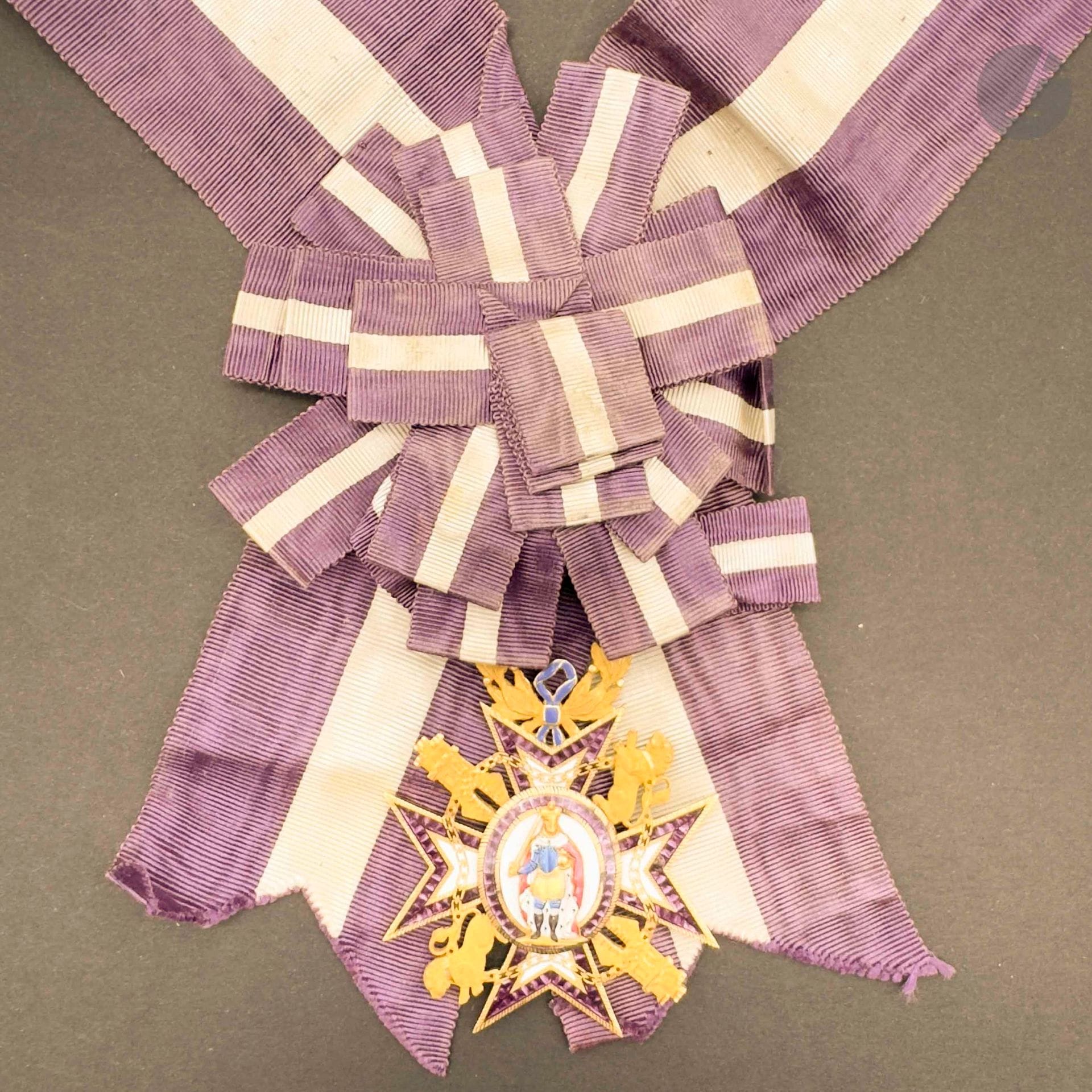 ESPAGNE 
ORDRE DE MARIE-LOUISE
Insigne de dame chevalier en or ciselé et émail. Poinçon au hibou. La couronne de lauriers fixe. Anneau de suspente lisse avec sa fine écharpe moirée avec nœud. 
62 x 50 mm - Poids brut: 20 g 
Le centre en plusieurs parties à l’avers (petits éclats). 
T.T.B. Vers 1850-1860.
Provenance : Collection du général Chollet