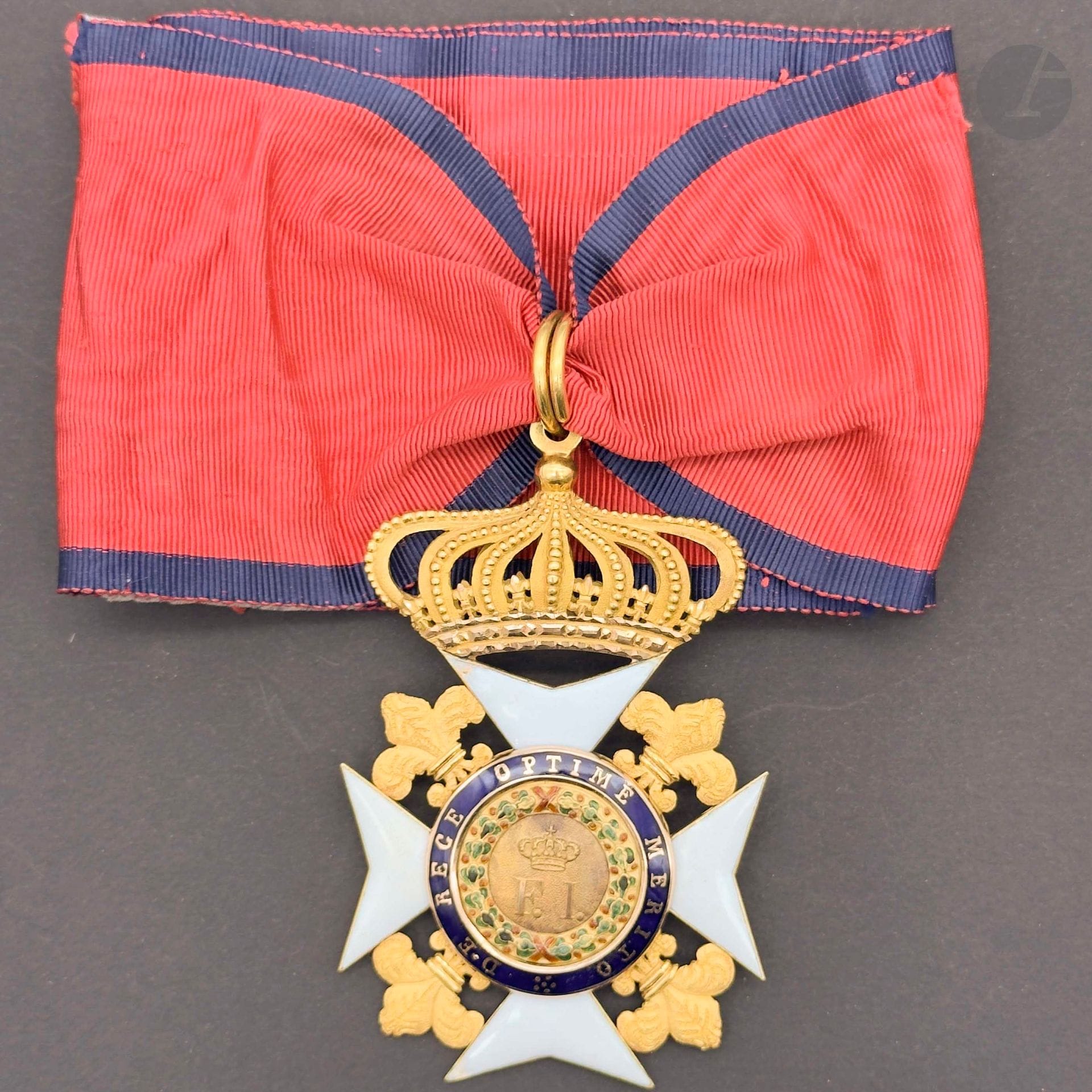 ROYAUME DES DEUX-SICILES 
ORDRE ROYAL DE FRANÇOIS Ier 
Insigne de commandeur en or et émail (éclats, restauration d’émail blanc au revers d’une des branches). Anneau double de suspente. Importante et large cravate sans attache (déchirée et restaurée). 
86 x 60 mm - Poids brut: 47 g
T.B. à T.T.B.
Provenance : Collection du général Chollet