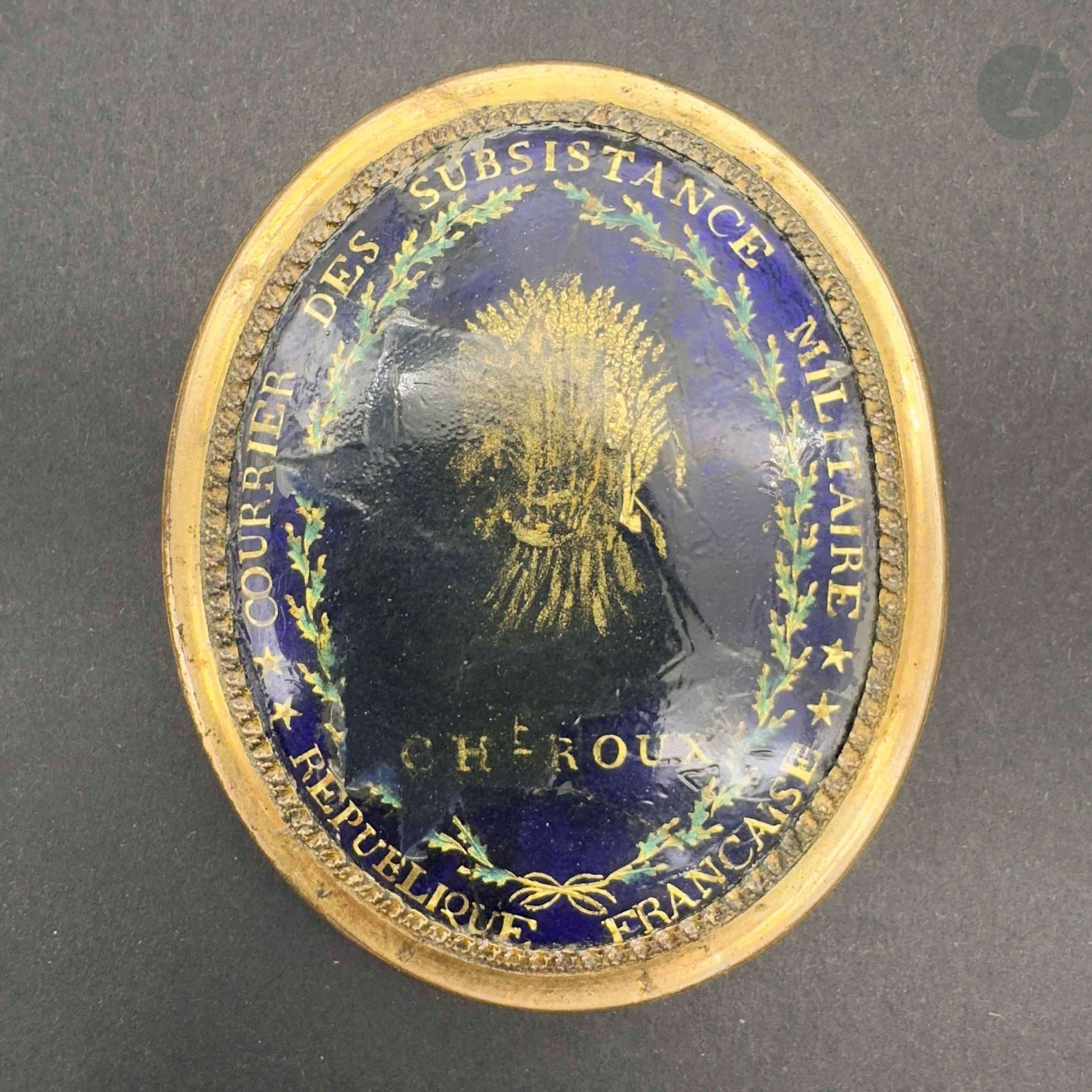 FRANCE
Rare plaque de courrier des subsistances militaires. Cerclage en laiton doré avec médaillon central en émail bleu marqué à l’or « courrier des subsistance militaire – République Française » et décoré au centre d’une gerbe de blé, marqué «cht roux ». Revers en cuivre à deux passants d’attache. 
55 x 47 mm 
A.B.E. (importantes restaurations à l’émail sur la partie centrale). Époque révolutionnaire. 

L’inscription évoque la ville de Châteauroux.